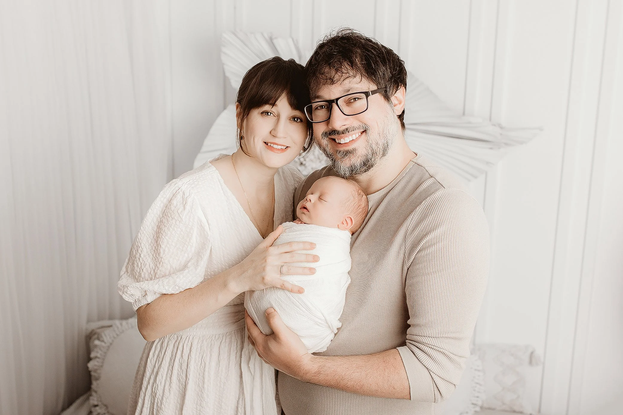 Parents embracing newborn baby in calm Ipswich studio setting