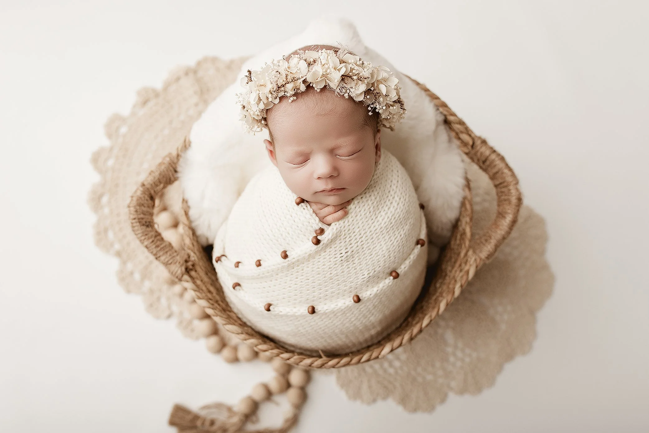Newborn baby girl wrapped in soft neutral tones in Ipswich newborn photography studio
