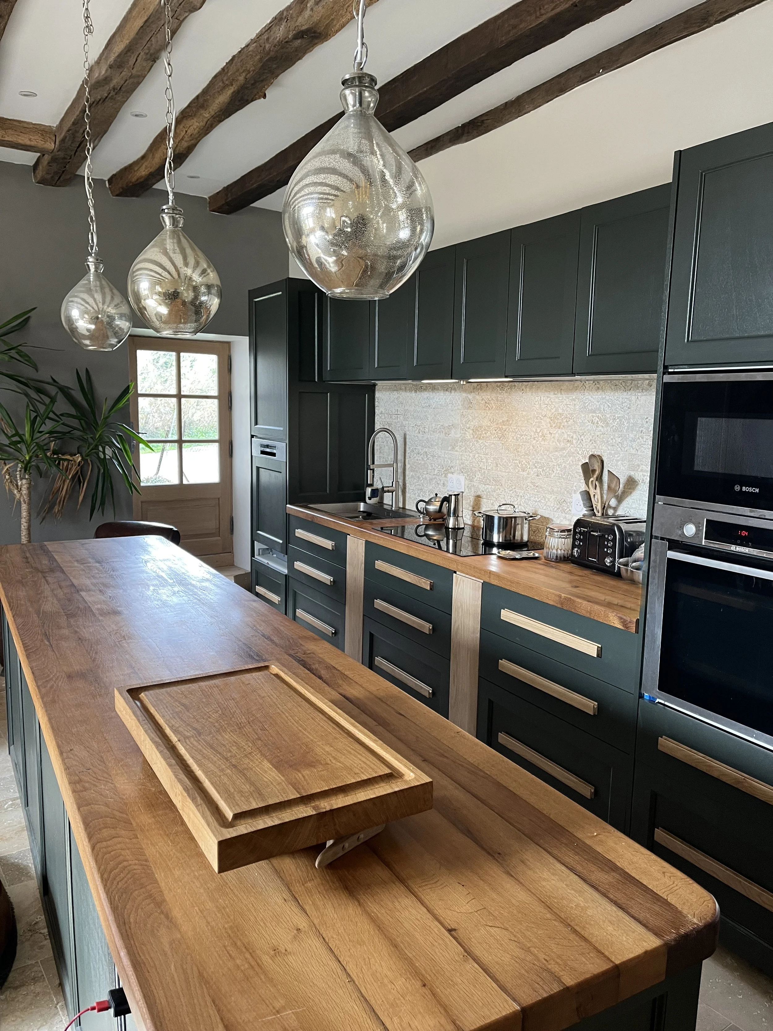 Cuisine en chêne peint avec plans de travail issus des poutres d'origine d'une maison du XVIe siècle. Porte arrière en chêne massif fabriquée sur mesure 
