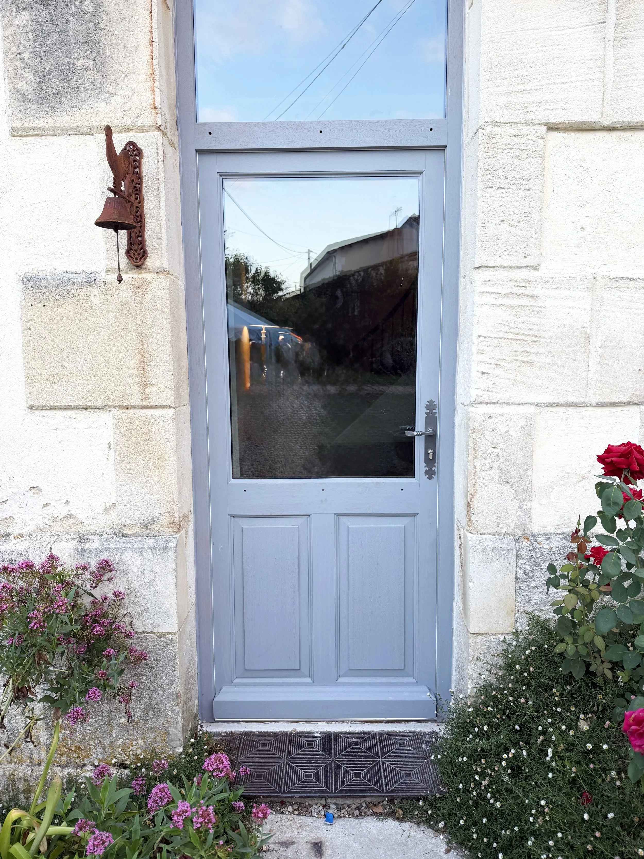 Cognac (16) — porte vitrée en bois, dessinée pour laisser entrer la lumière dans une entrée sombre.