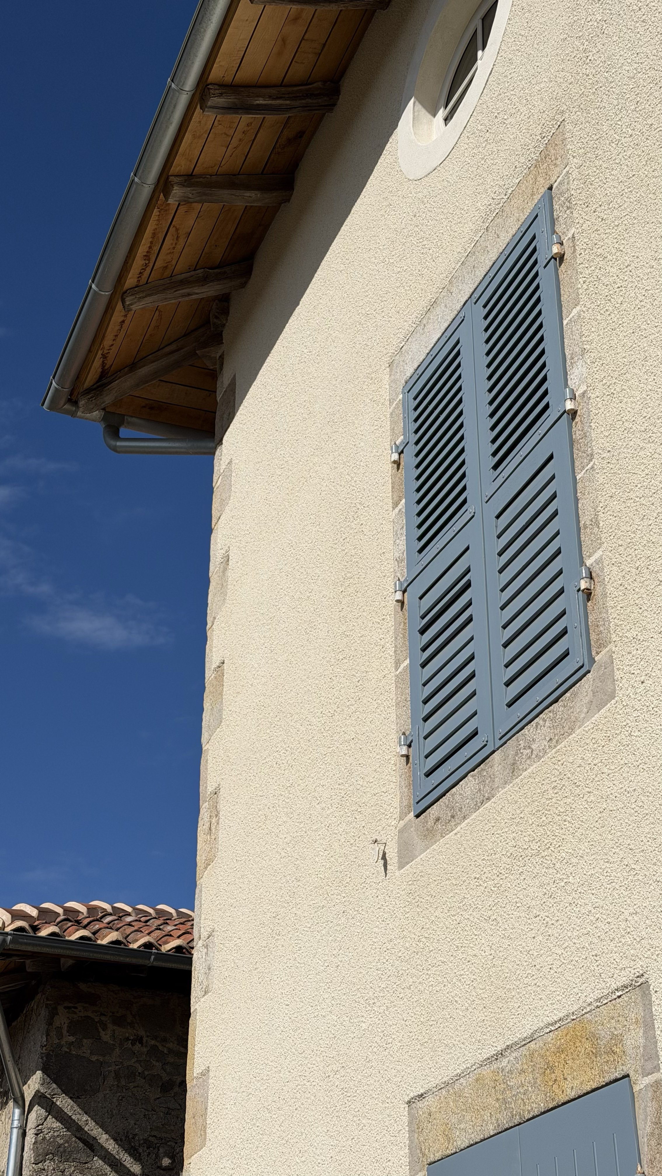 Volets persiennés en bois sur une maison en pierre, Les Cars (87)