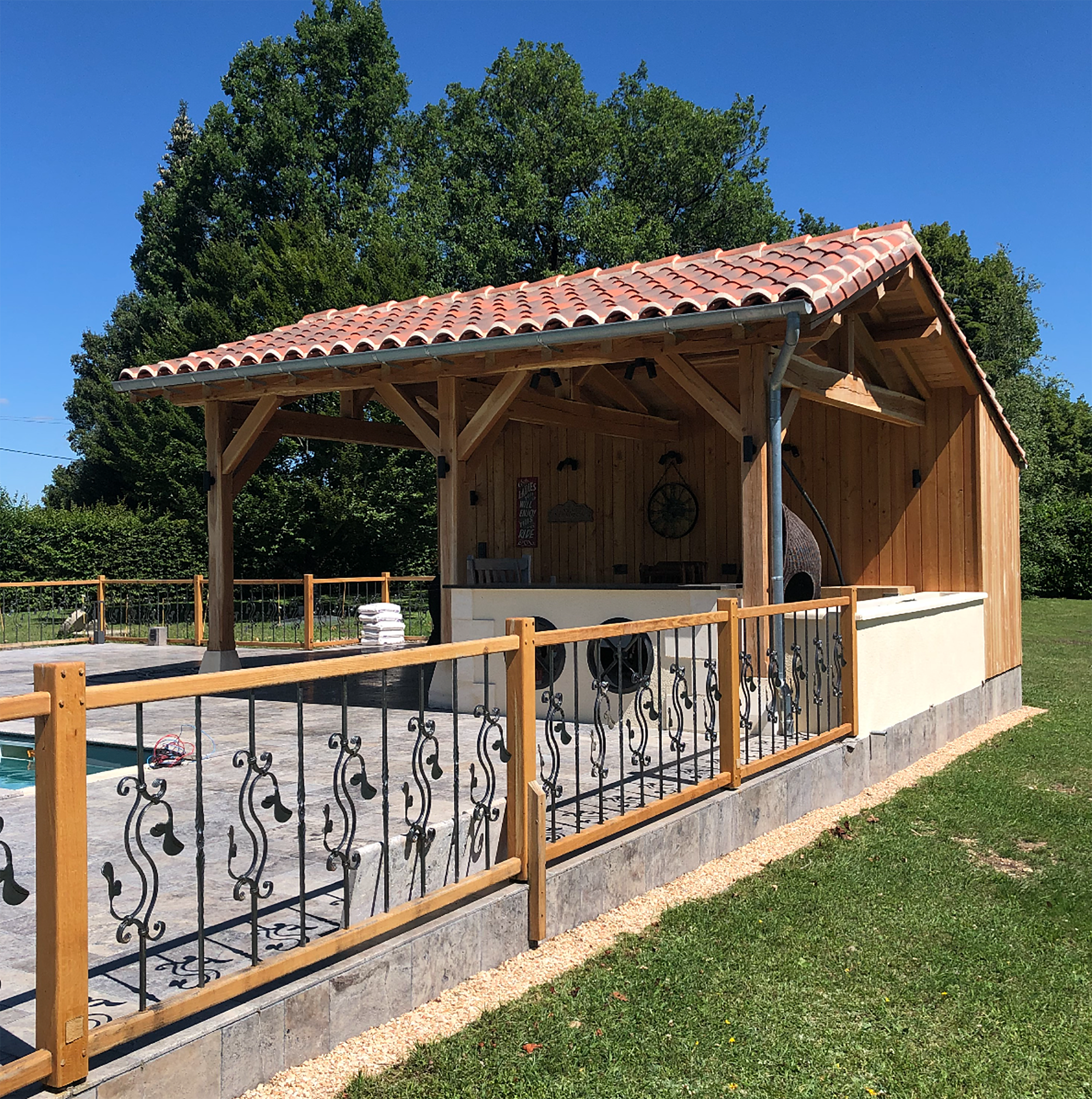 Pool house à charpente bois au bord d'une piscine en Dordogne