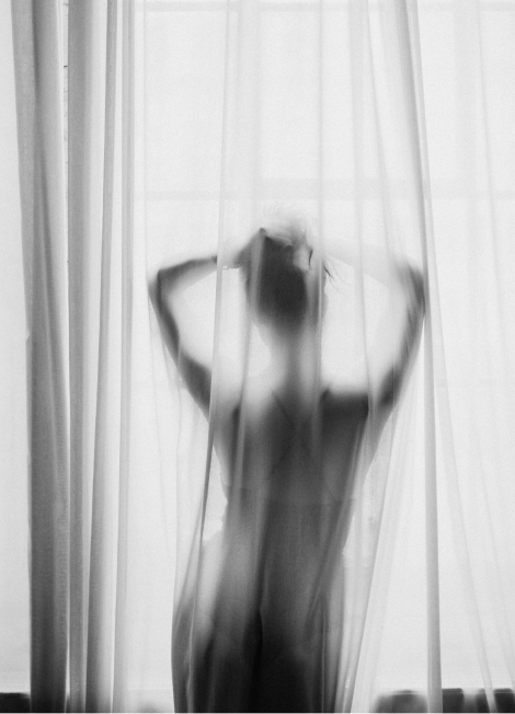 Silhouette of a person behind sheer curtains