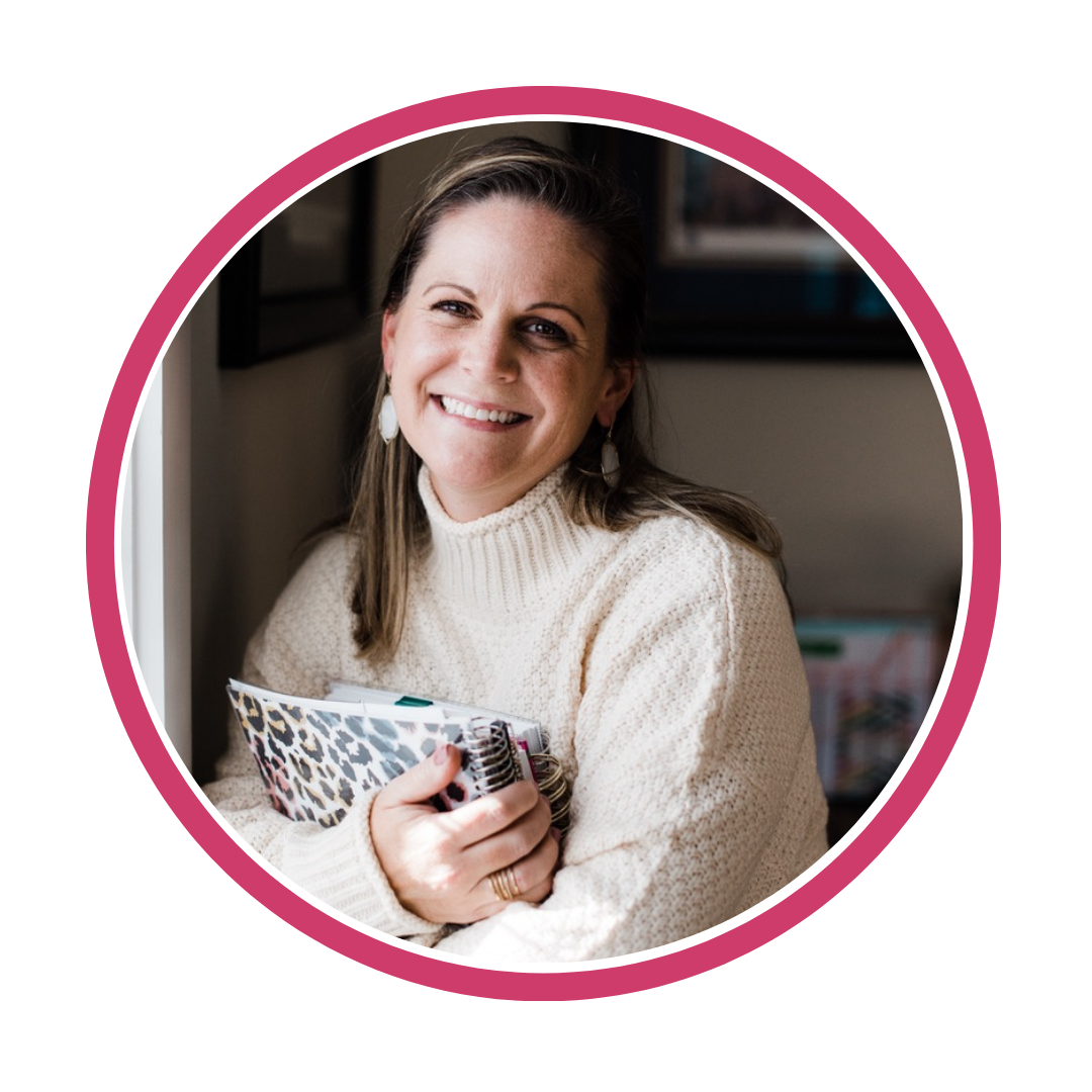 Smiling person in a white sweater holding notebooks