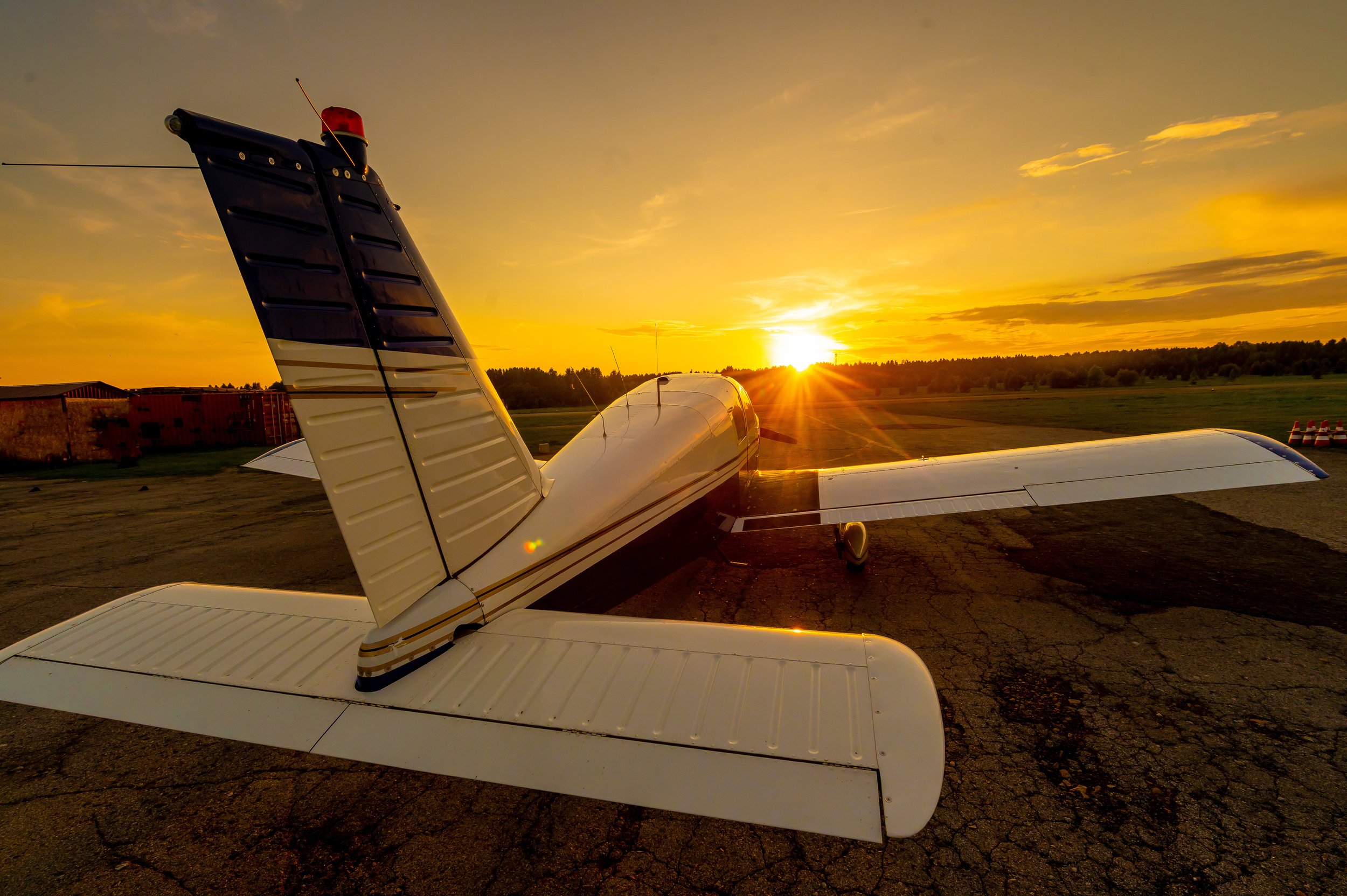 Private plane on runway with sunset in background