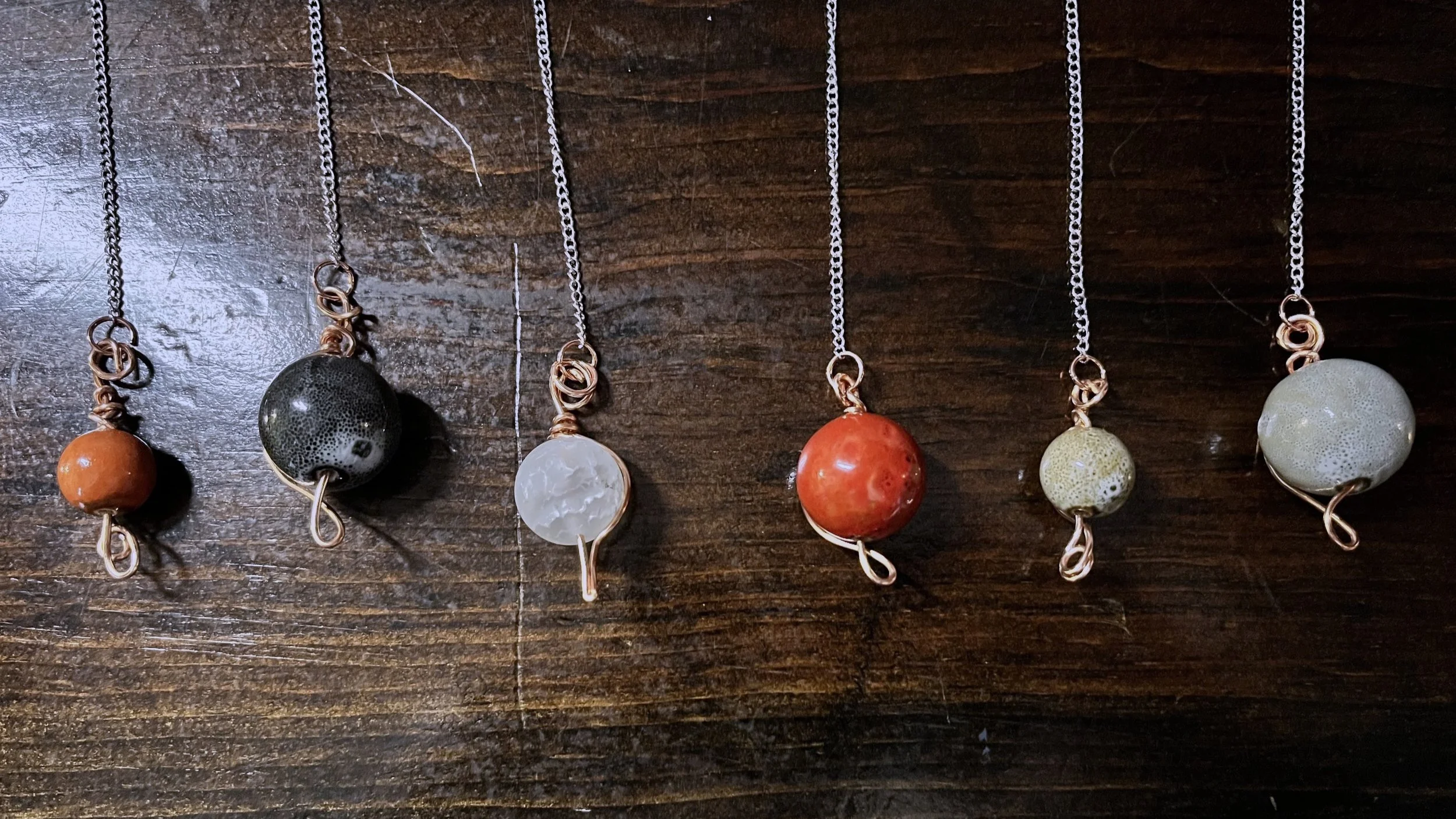 Row of 6 pendulums of different colors 