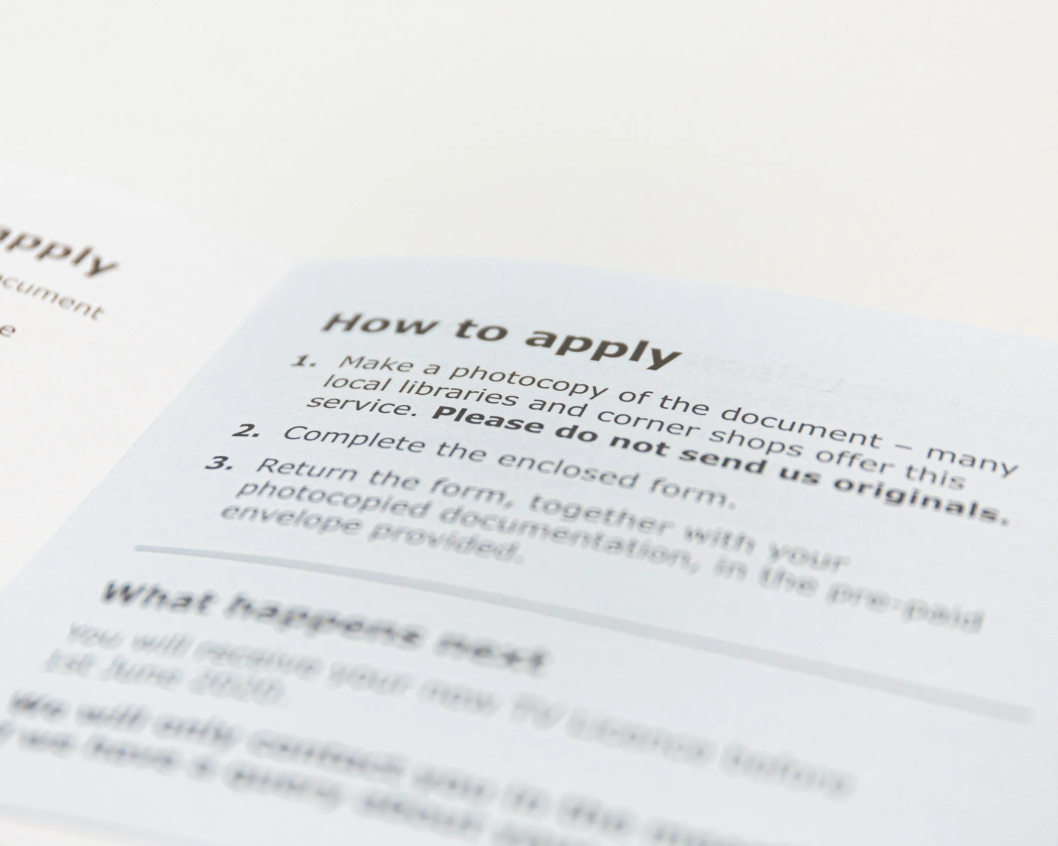 Close-up of a printed instruction sheet titled 'How to apply', listing steps for submitting a photocopy of a document.
