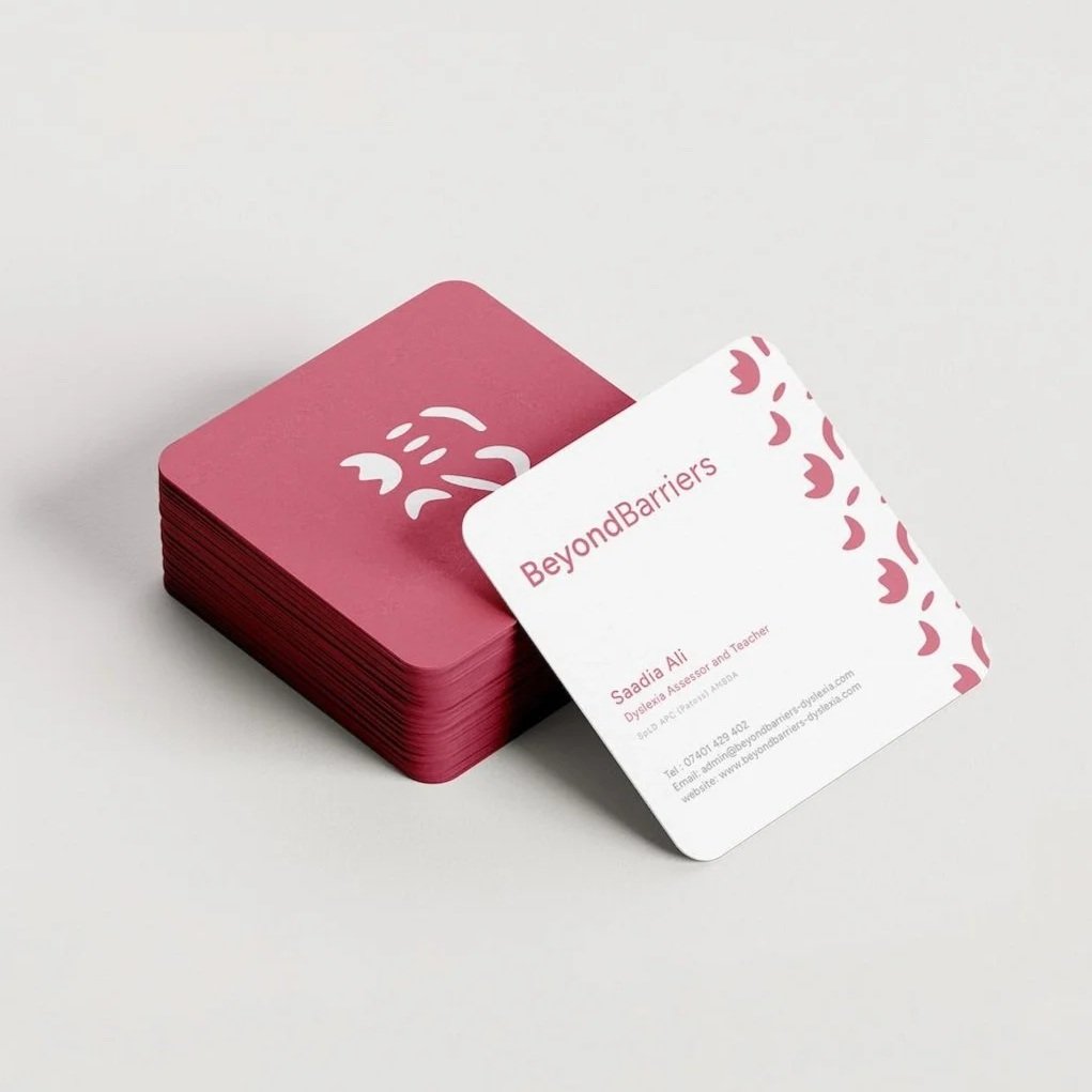 Stack of dusty rose business cards for Beyond Barriers featuring logomark and brand pattern