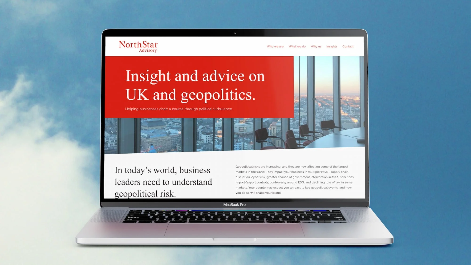 A laptop displaying a website about geopolitical risk and advice, with a cityscape visible through the office windows in the background.