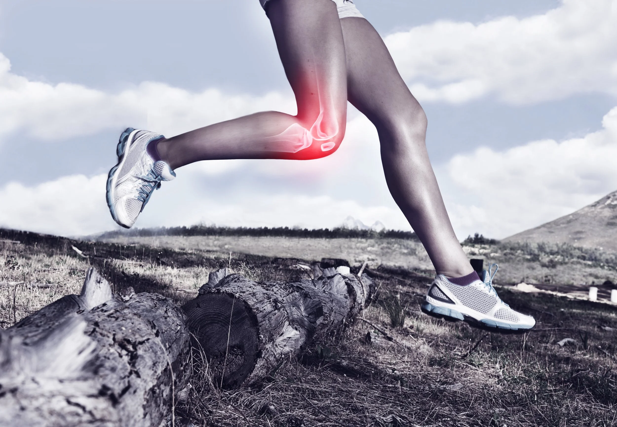 A person running outdoors on a trail with mountains in the background, wearing running shoes. The knee of the person is highlighted with a red glow and a digital illustration of a knee joint, indicating knee pain or injury.
