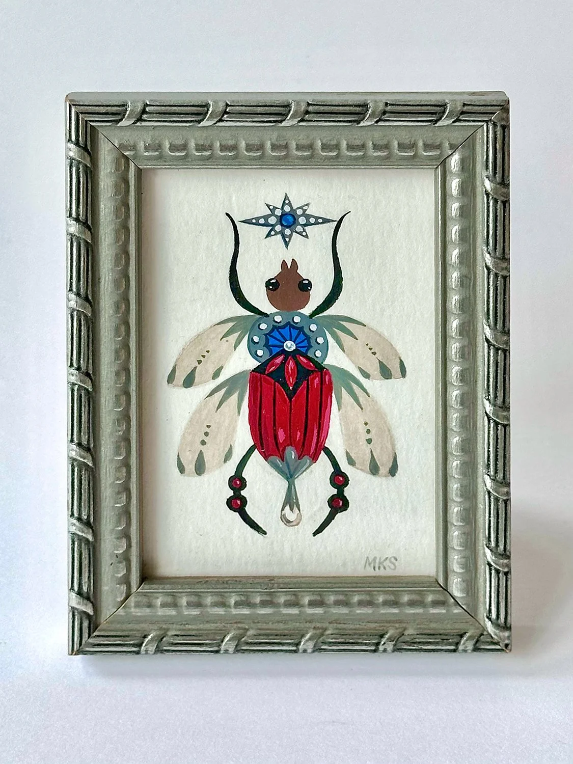 Miniature beetle with jewel accents, in silver frame.