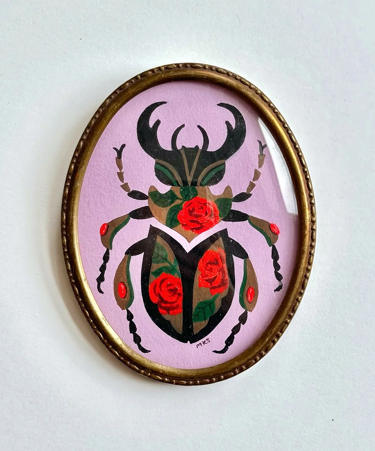 Miniature gouache beetle with roses in oval frame.