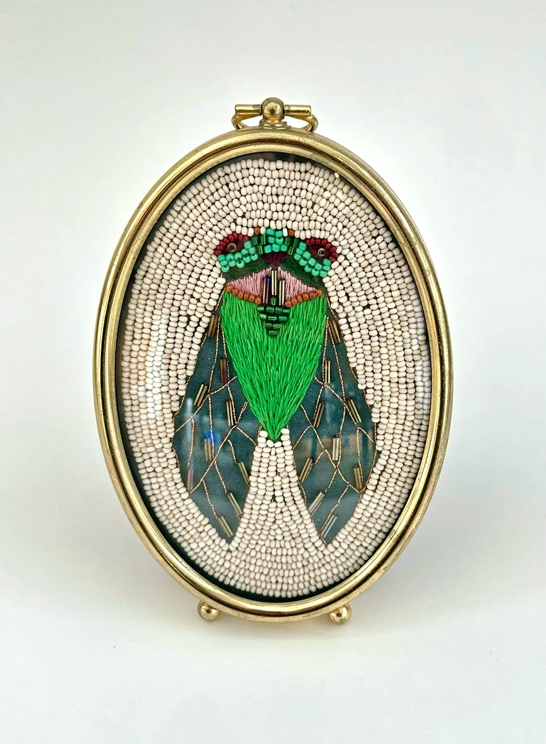 Miniature beaded and embroidered cicada in oval frame.