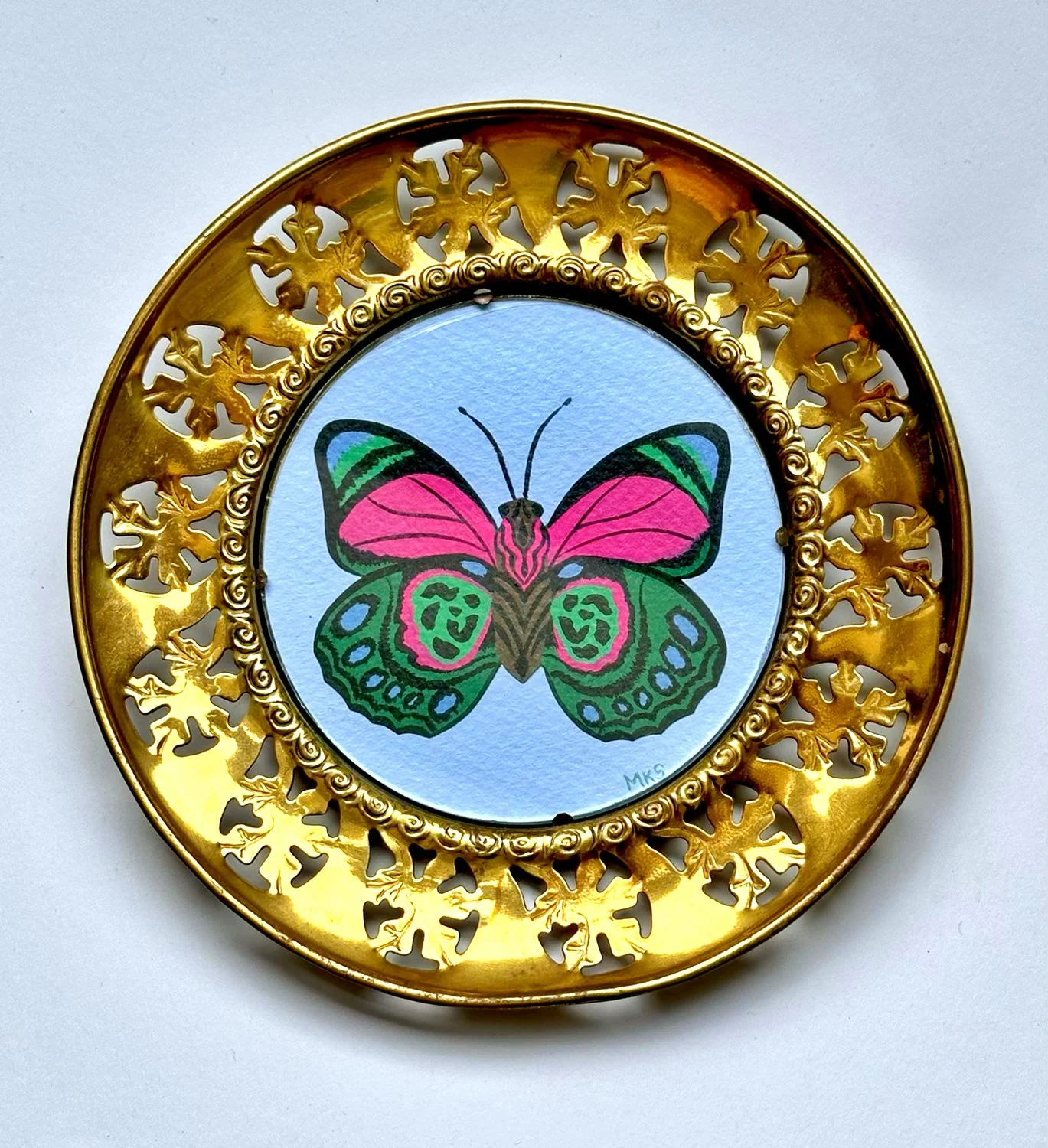 Gouache butterfly in decorative circle frame.