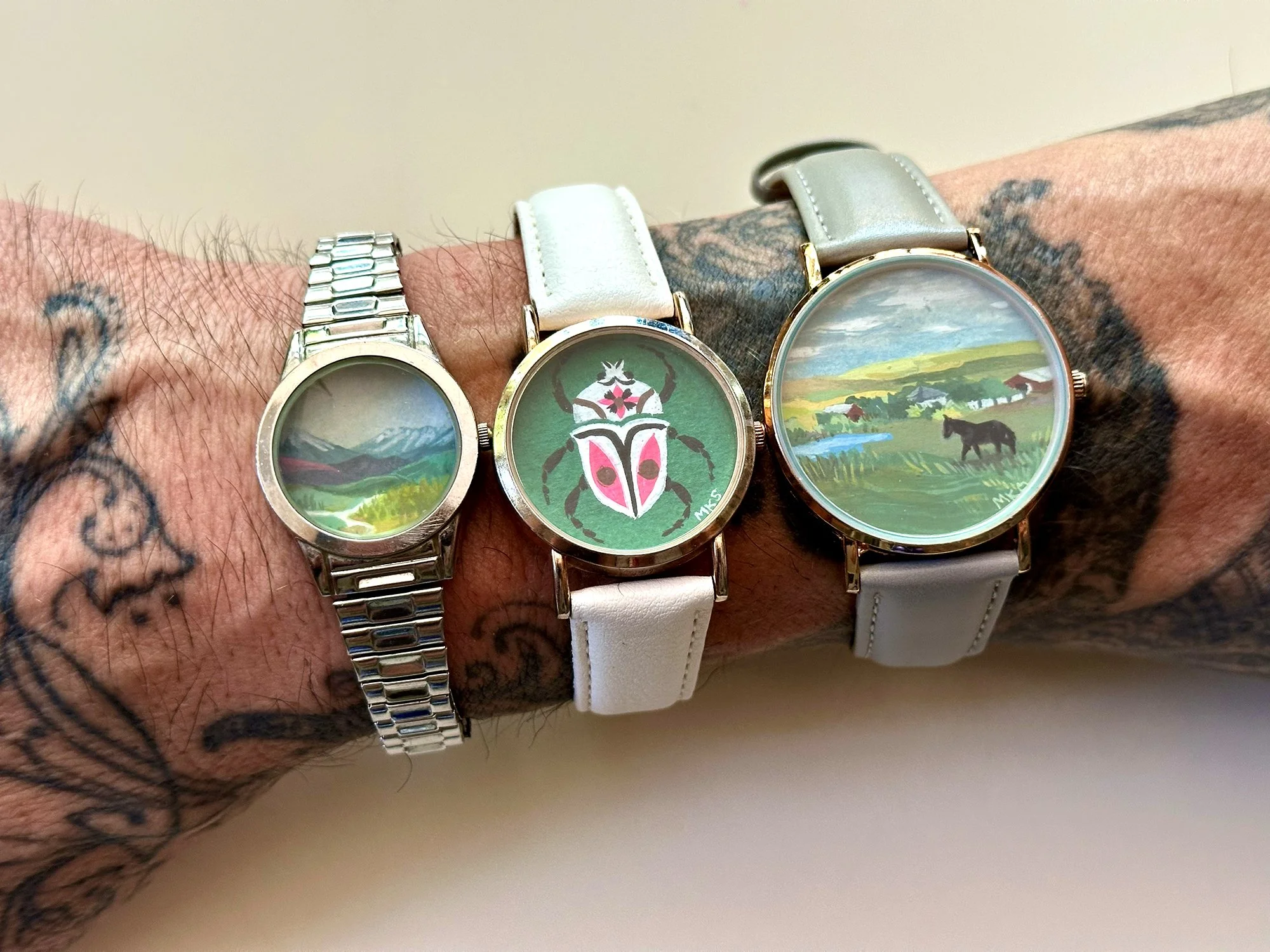 Art bracelets with landscapes and beetle.