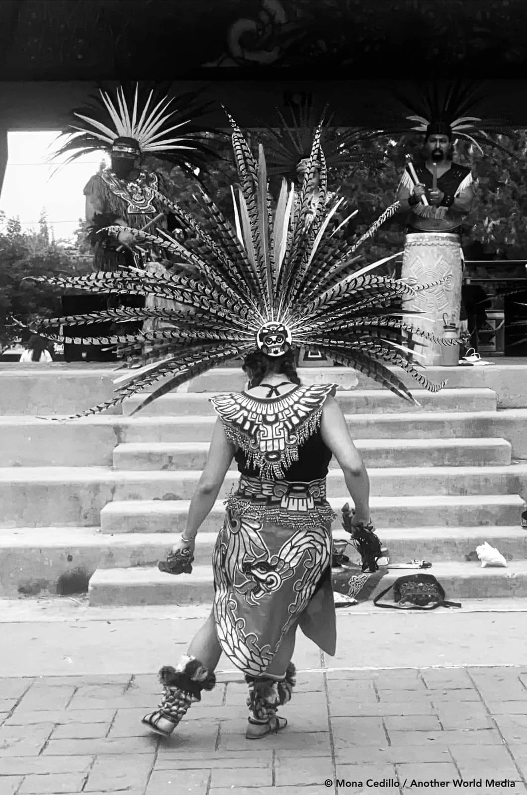 Aztec female warrior bows in reverence to offering before ritual of Aztec dancers at La Raza Park in Denver, Colorado
