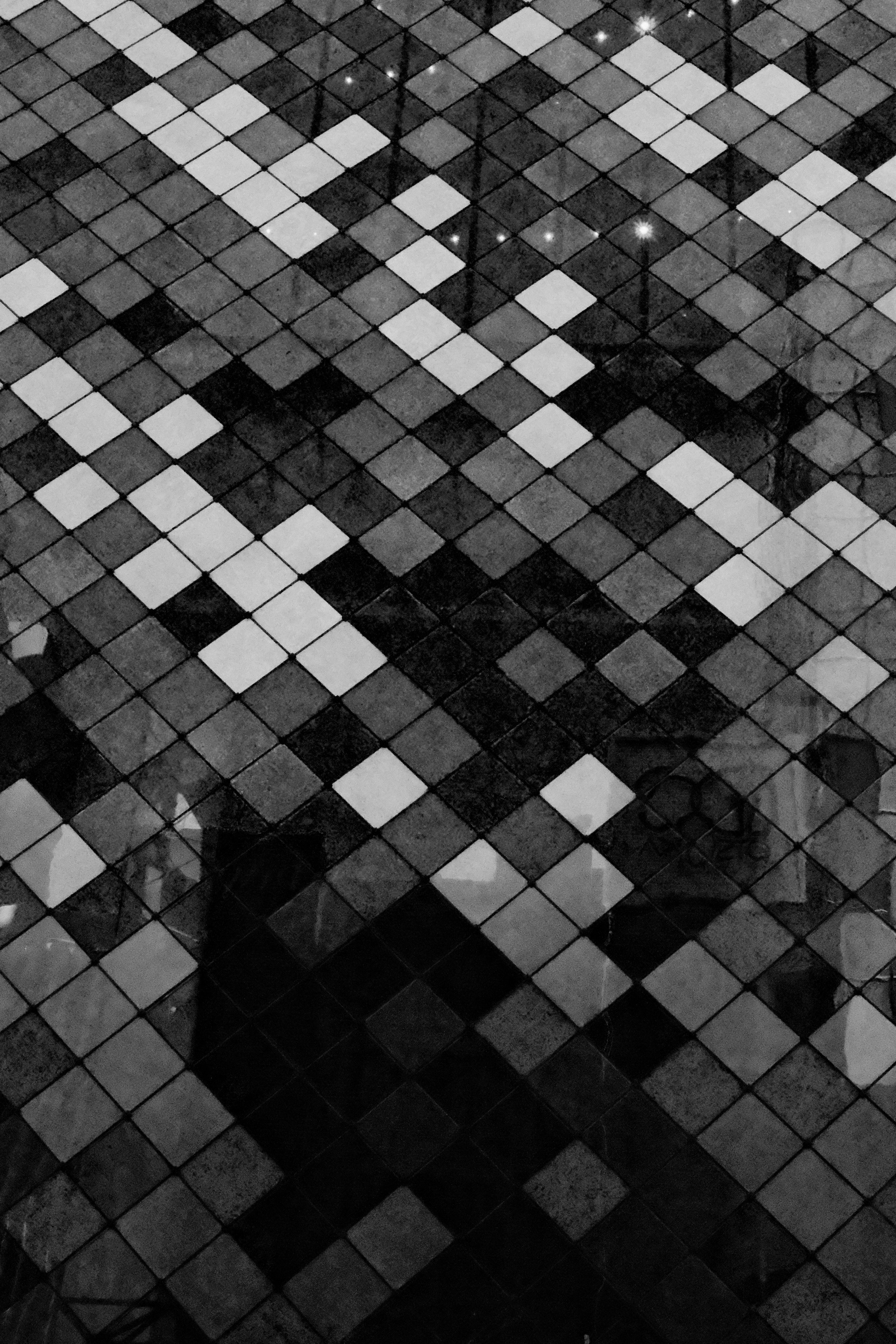 Black and white geometric pattern of tiled squares, creating a checkerboard effect.