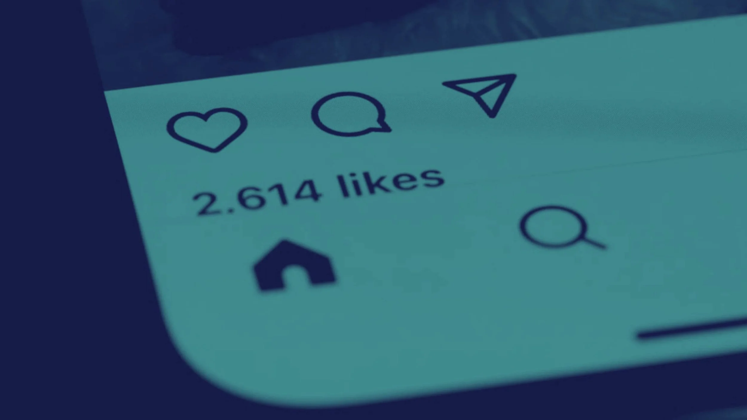 Close-up of a social media notification showing 2,614 likes, with icons for like, comment, share, and explore.