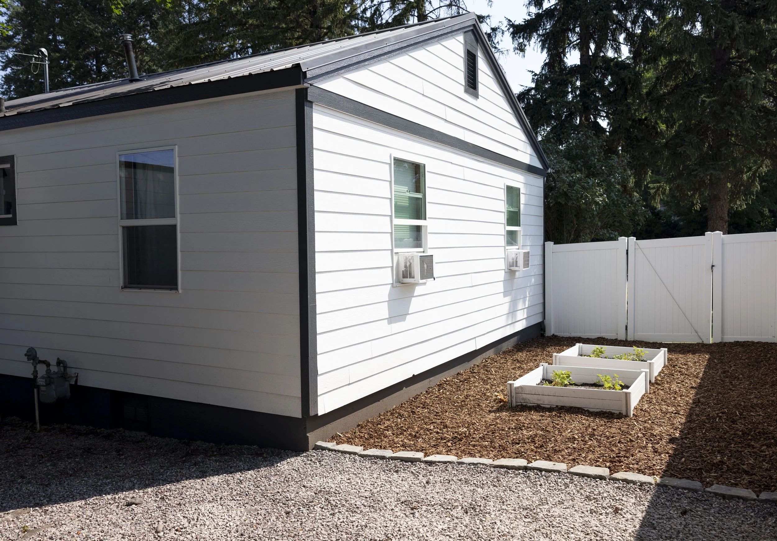 Whitefish Painting Company paints white exterior with black trim in Columbia Falls, Montana.
