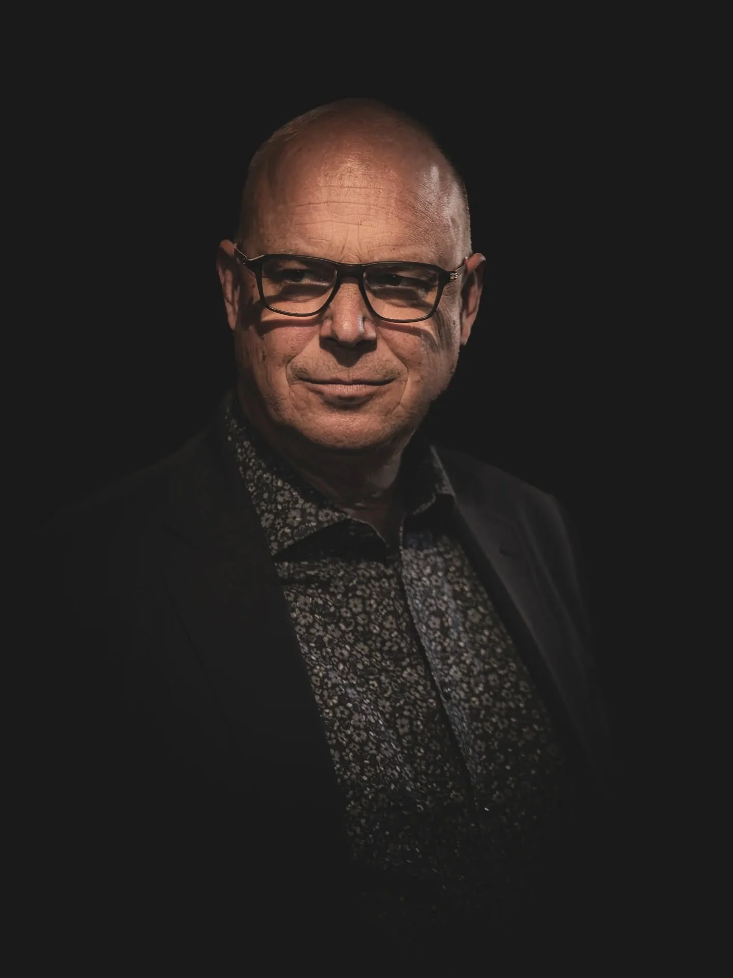 This may look like a studio portrait, but this was actually taken at a corporate networking event. When I saw the raw file, I instantly felt this image could become dramatic and strong in intention.

The second image is the original photo to show the