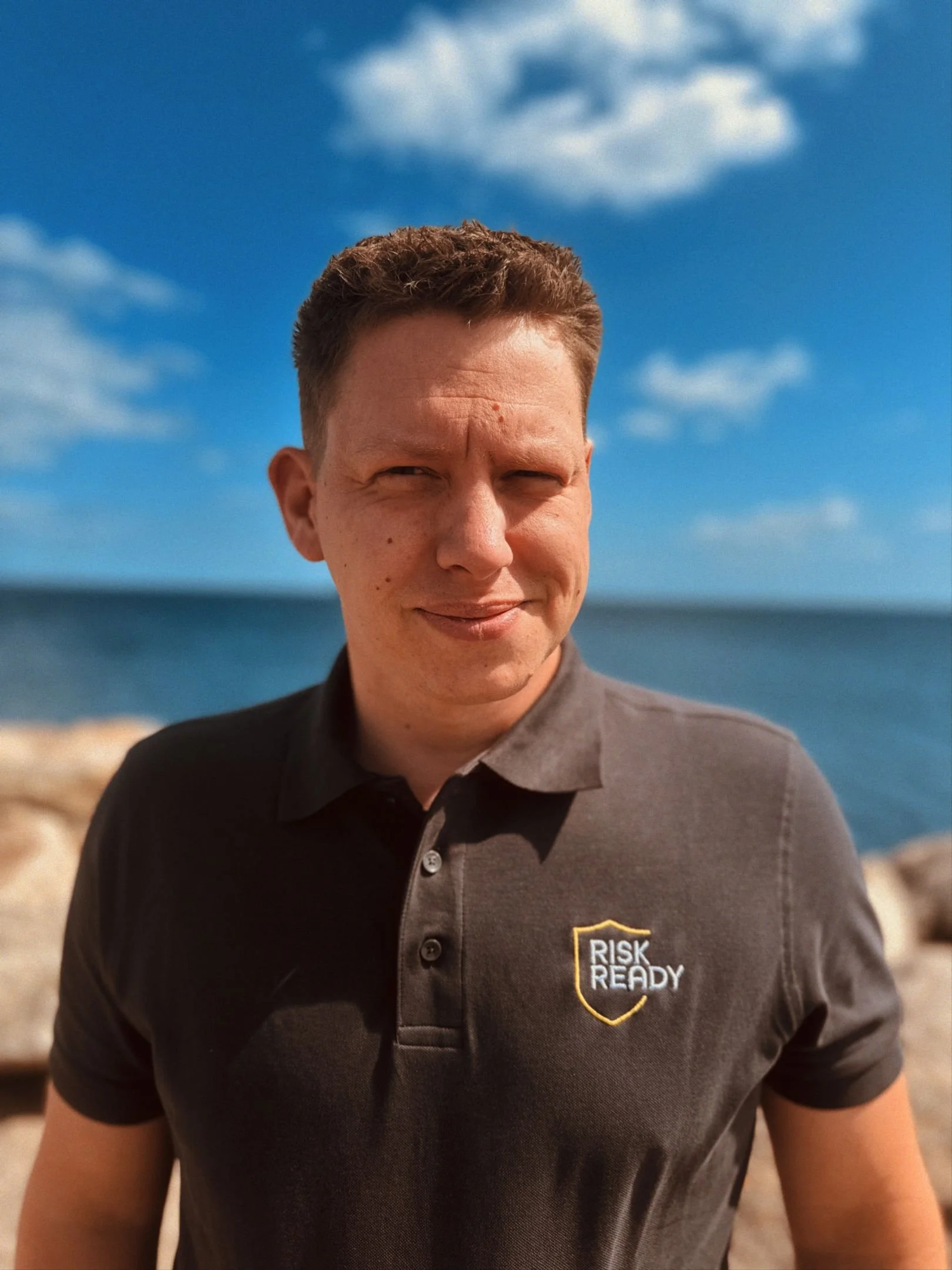 Beredskabskonsulent fra Risk Ready ved havet iført firmapolo – specialist i mental parathed.