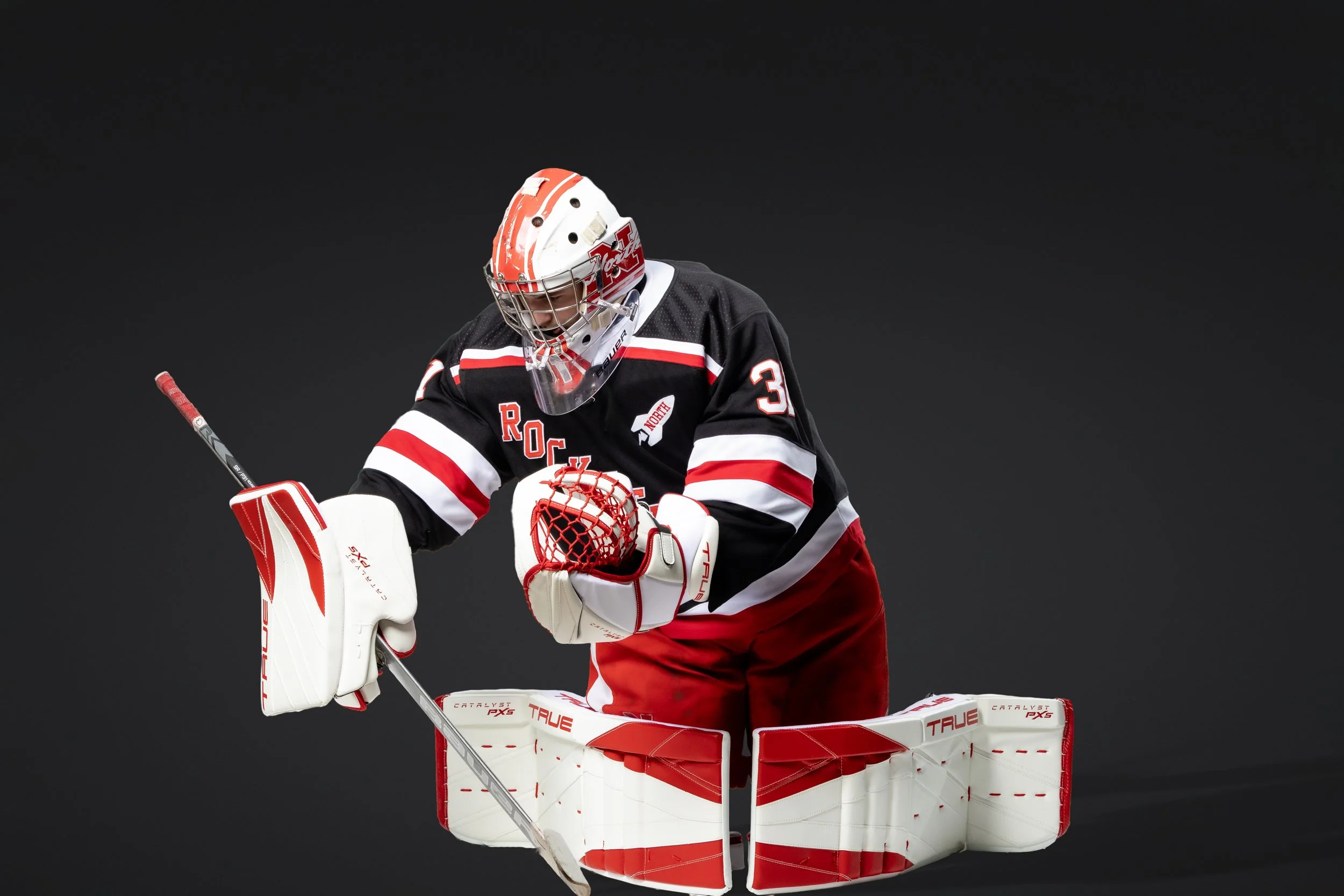 Studio sports portrait of a high school hockey goalie in action in Massachusetts