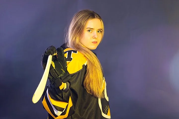 Studio sports portrait of a female hockey player holding her stick in Massachusetts
