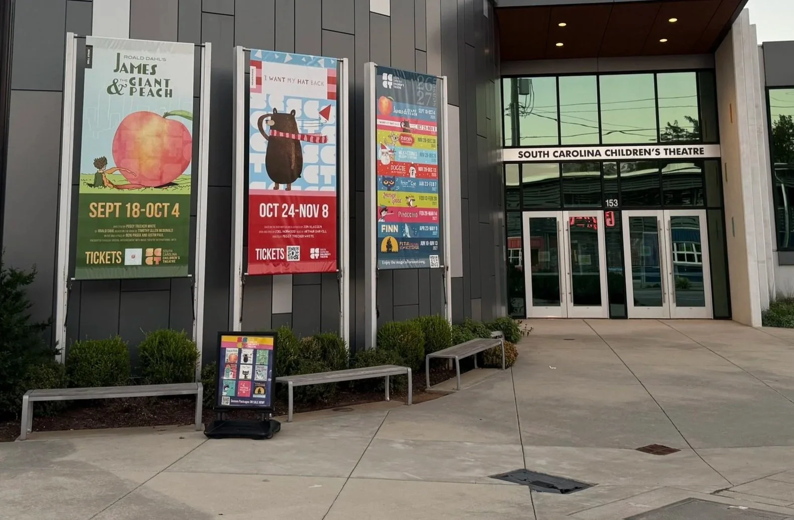 Entrance to South Carolina Children's Theatre with posters advertising shows and event dates outside the building.