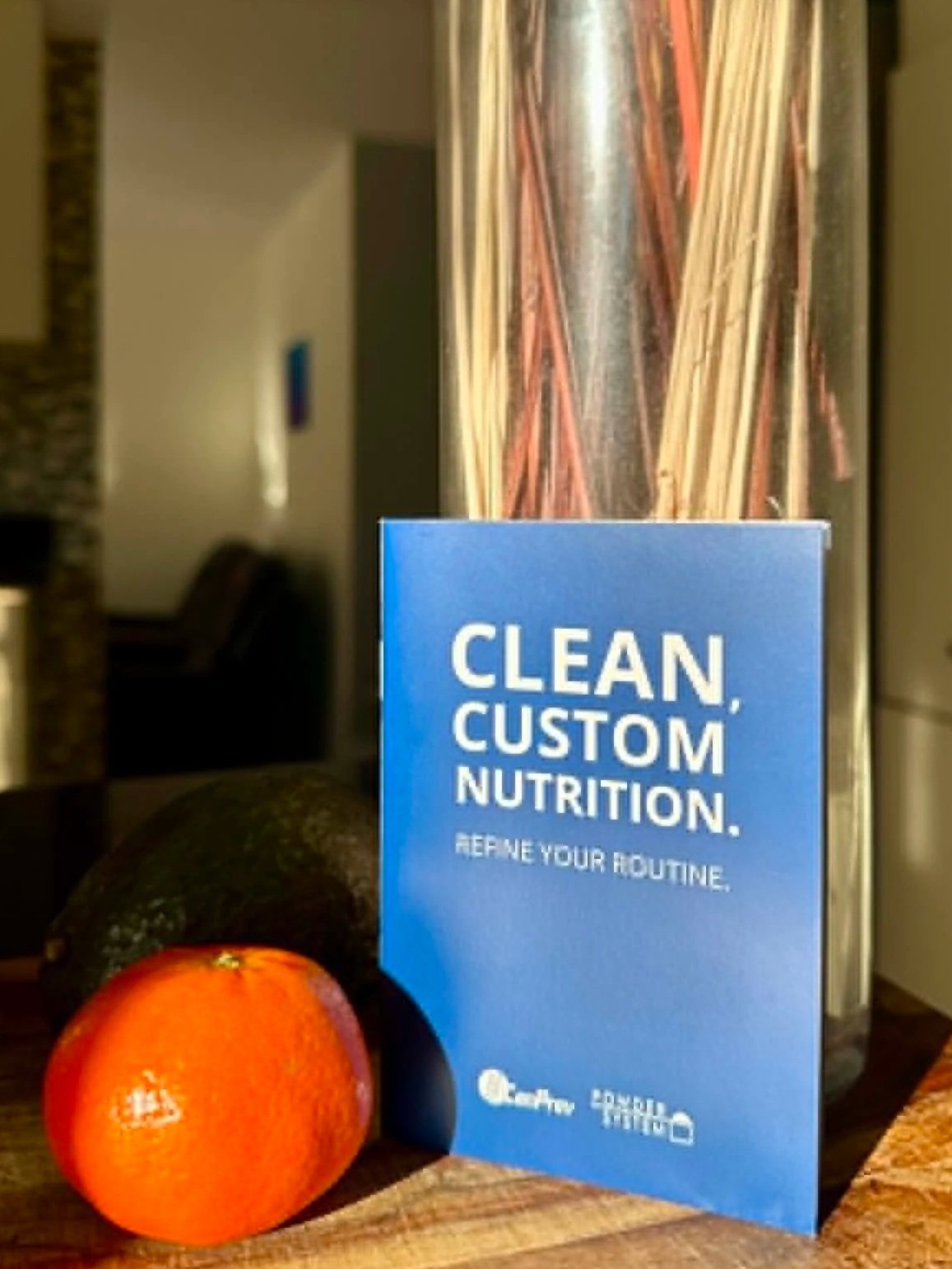 A booklet on top of a wooden cutting board beside an orange