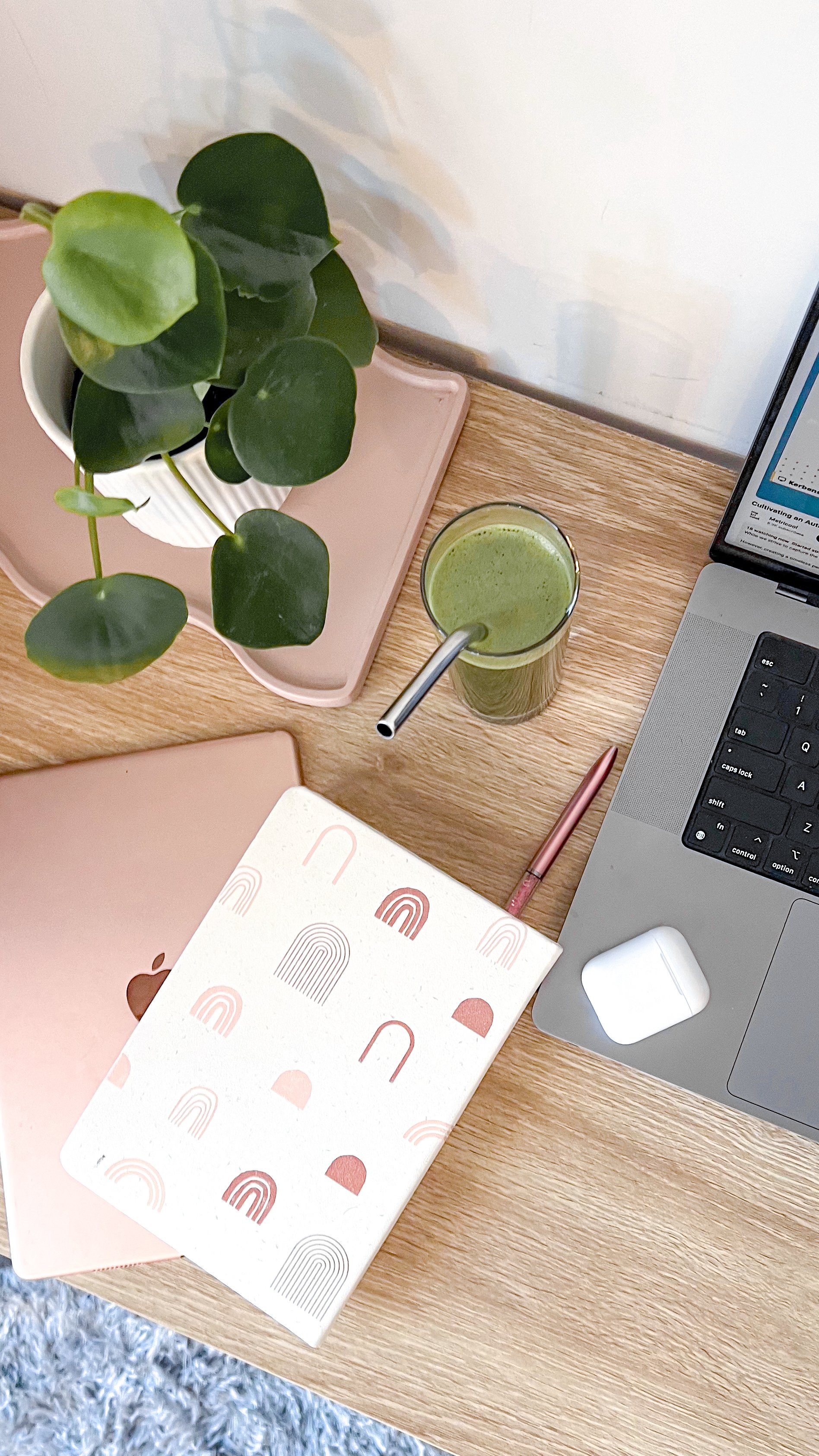 Cup of matcha with notes and laptop on the table.