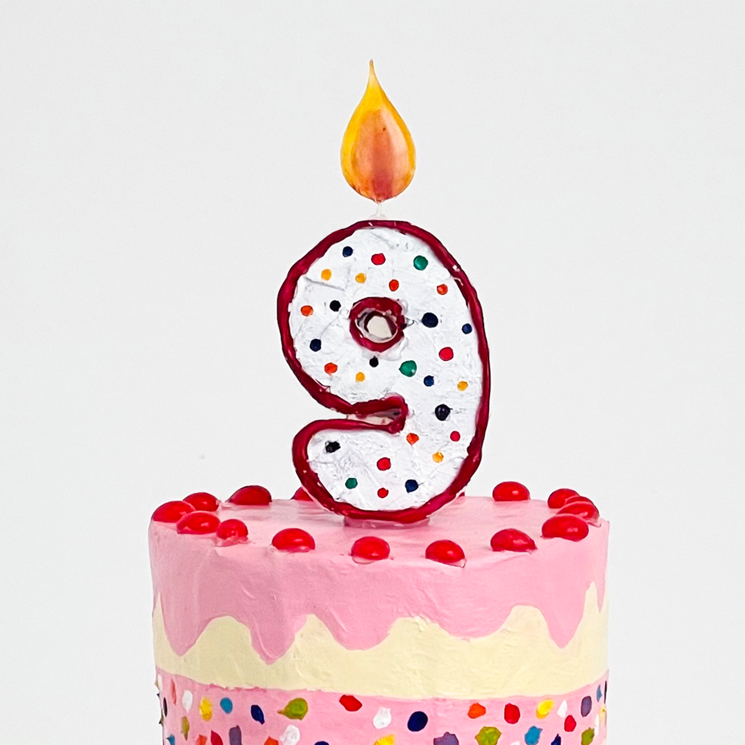 Close up of paper maché cake with candle for Creativeubug's 9th Birthday