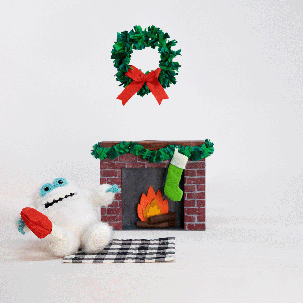 Stop-motion animation of Crocheted Abominable Snowman and Crocheted Sloth hanging stockings above the fireplace
