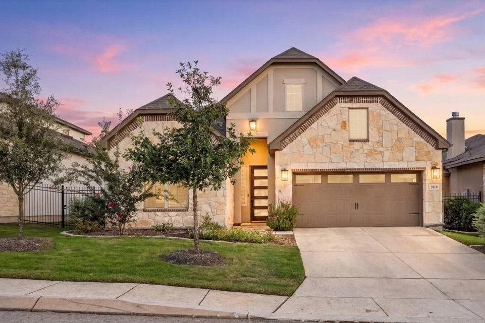 Front exterior of 1610 Bunchberry, a Sitterle home in the Kinder Ranch community of San Antonio, Texas, at sunset.