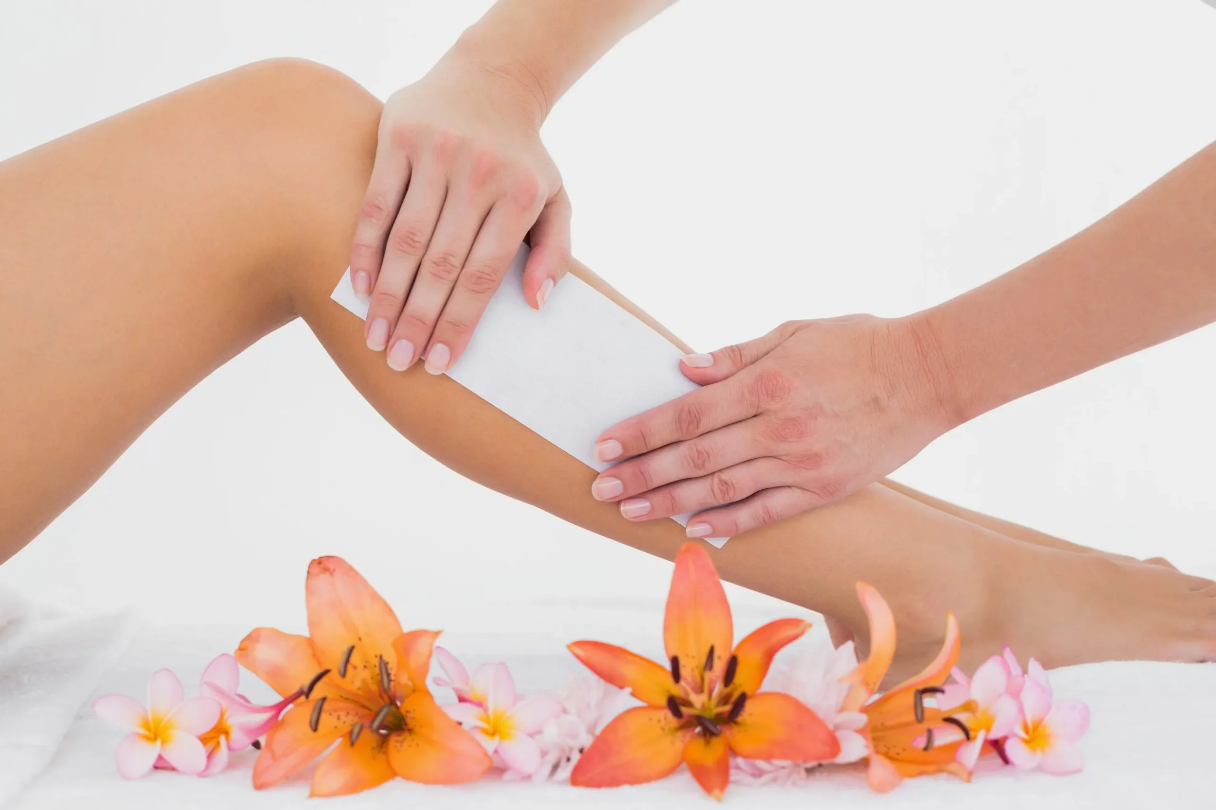 A person receiving a leg waxing treatment, with flowers at the base and a white background.