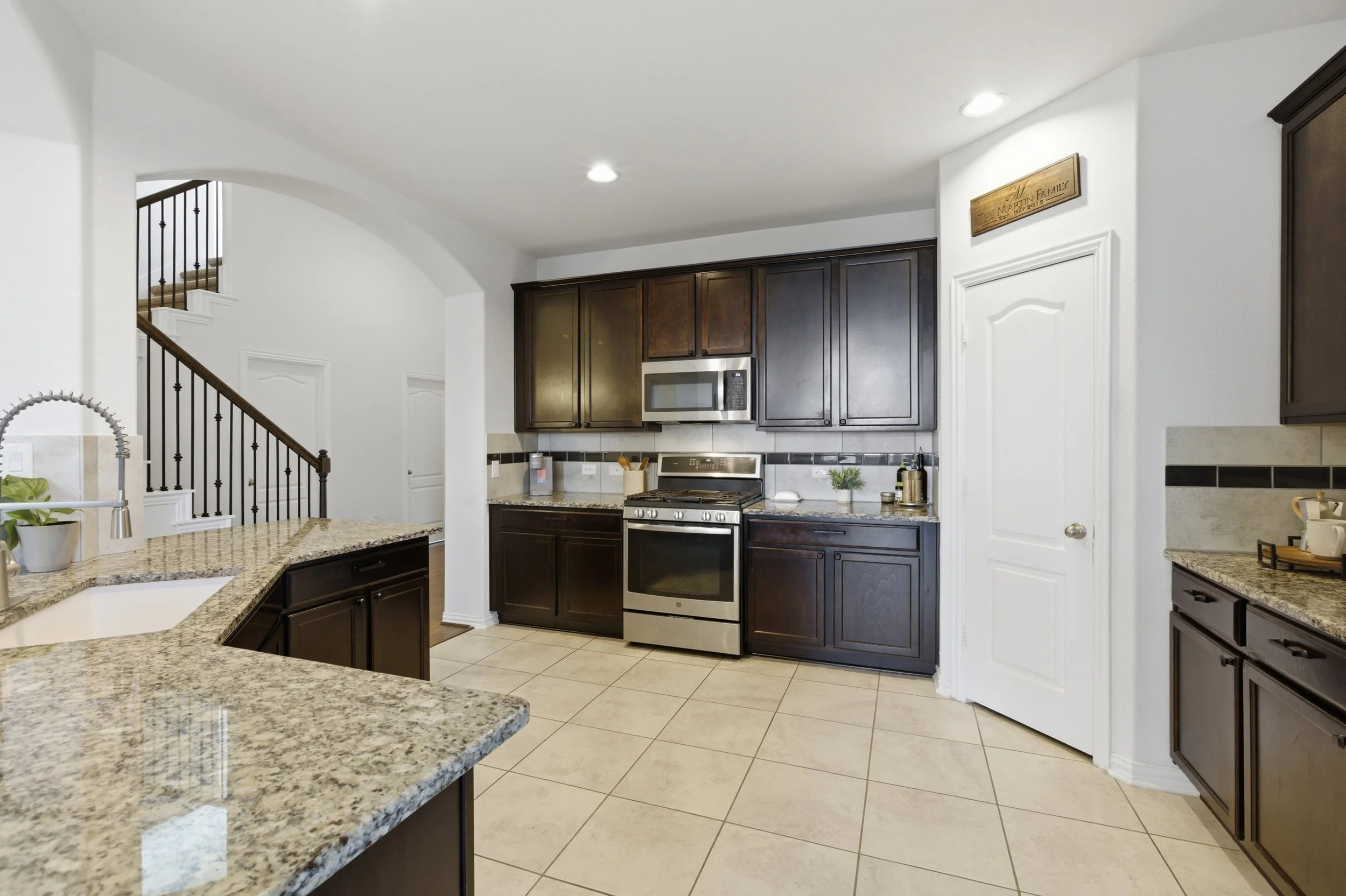 Modern kitchen at 5386 Parma St Round Rock TX featuring granite countertops, large island, and stainless steel appliances.