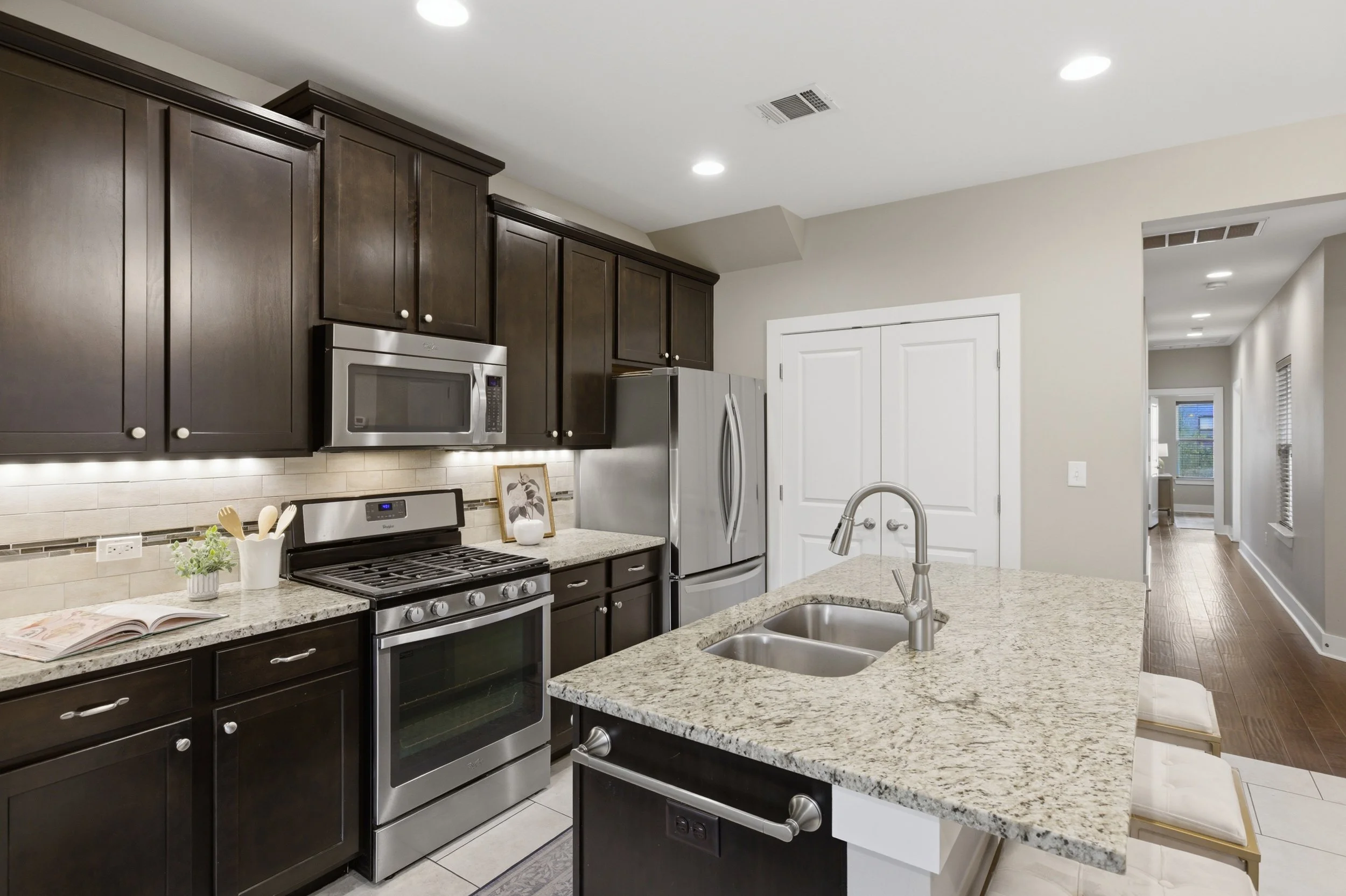 Modern kitchen with stainless steel appliances and eat-in island in Brentwood Austin Texas condo.”
