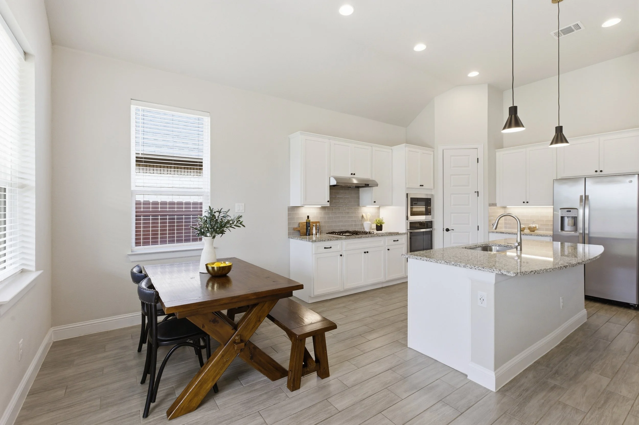 The kitchen features granite countertops, a large center island, built-in appliances, and a walk-in pantry | Georgetown, TX