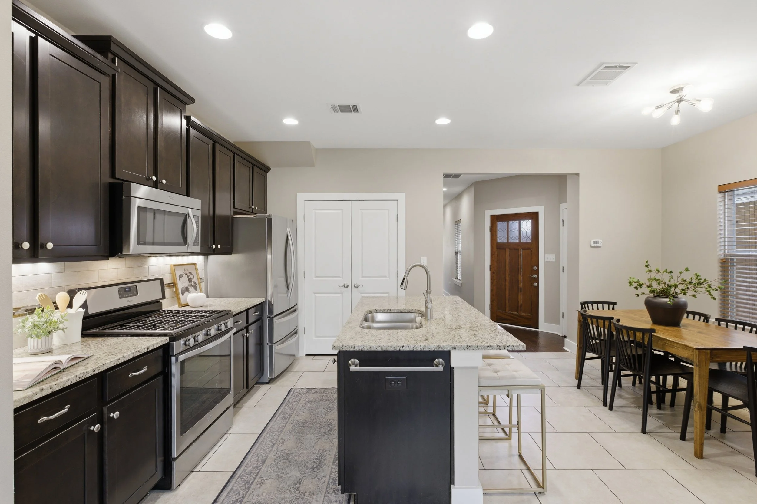 Modern kitchen with stainless steel appliances and eat-in island in Brentwood Austin Texas condo.”