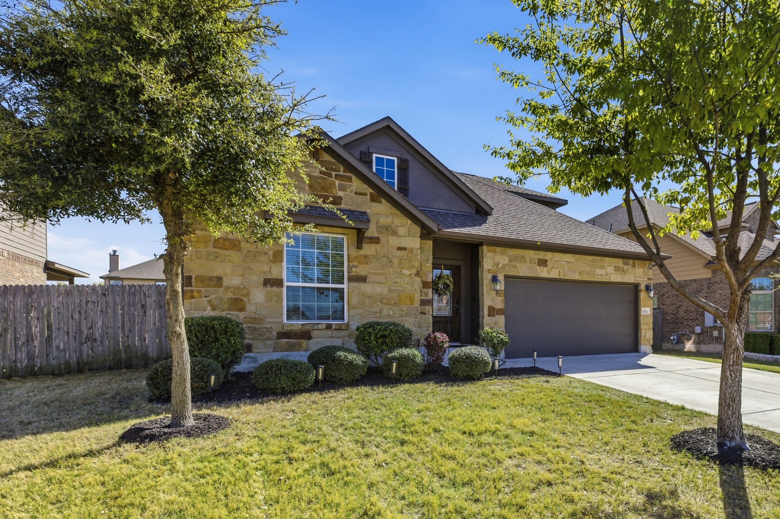 Front exterior of home for sale at 5386 Parma St, Round Rock TX in Siena neighborhood featuring brick and stone facade and landscaped front yard.
