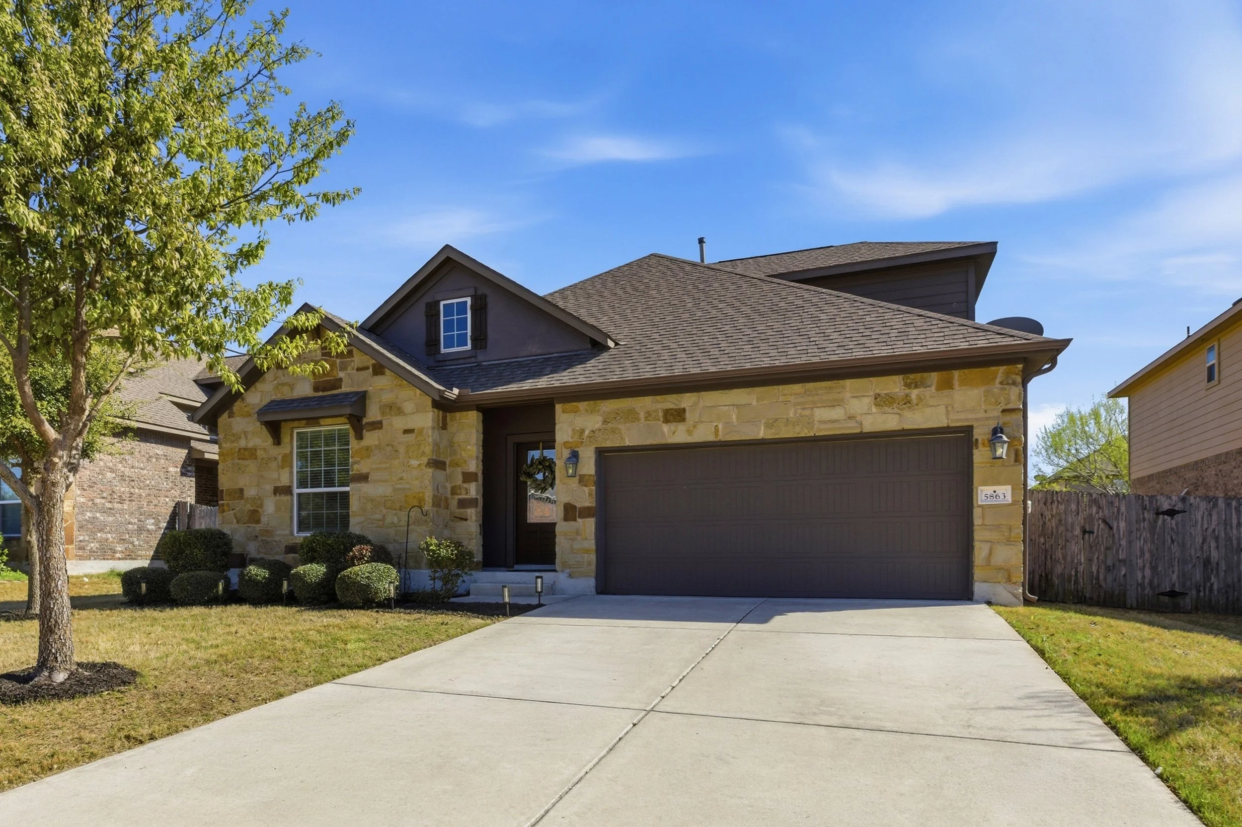 Front exterior of home for sale at 5386 Parma St, Round Rock TX in Siena neighborhood featuring brick and stone facade and landscaped front yard.