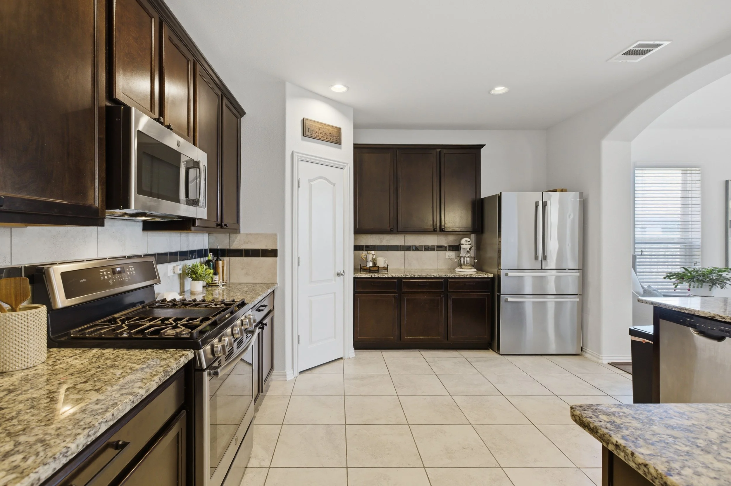 Modern kitchen at 5386 Parma St Round Rock TX featuring granite countertops, large island, and stainless steel appliances.