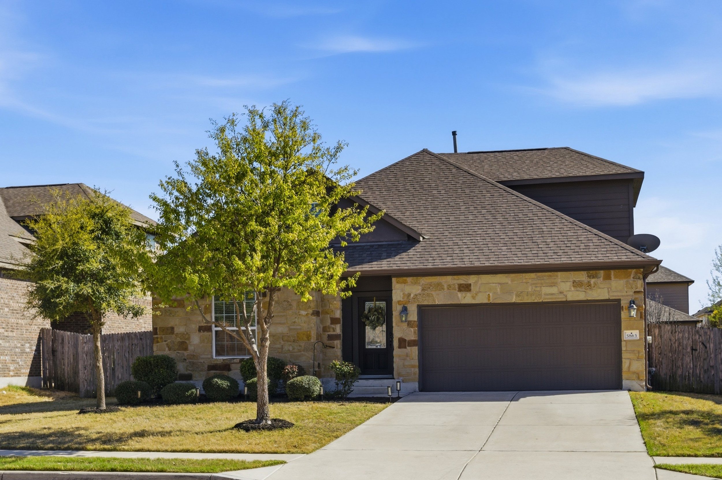 Front exterior of home for sale at 5386 Parma St, Round Rock TX in Siena neighborhood featuring brick and stone facade and landscaped front yard.
