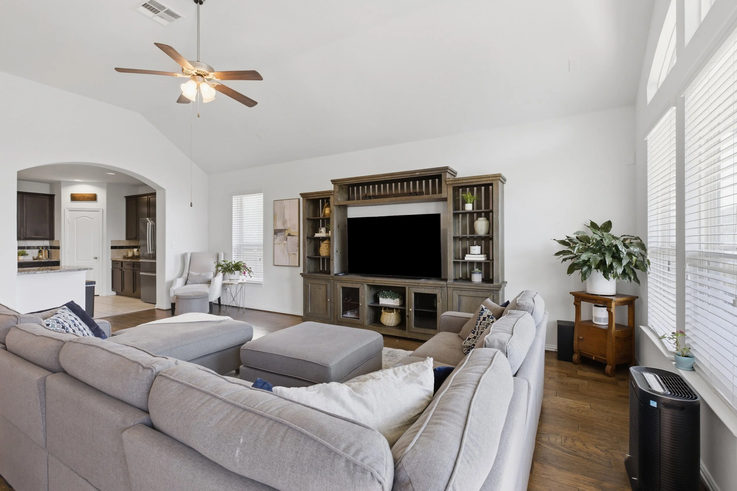 Open concept living room at 5386 Parma St Round Rock TX with large windows and natural light connecting to kitchen and dining areas.
