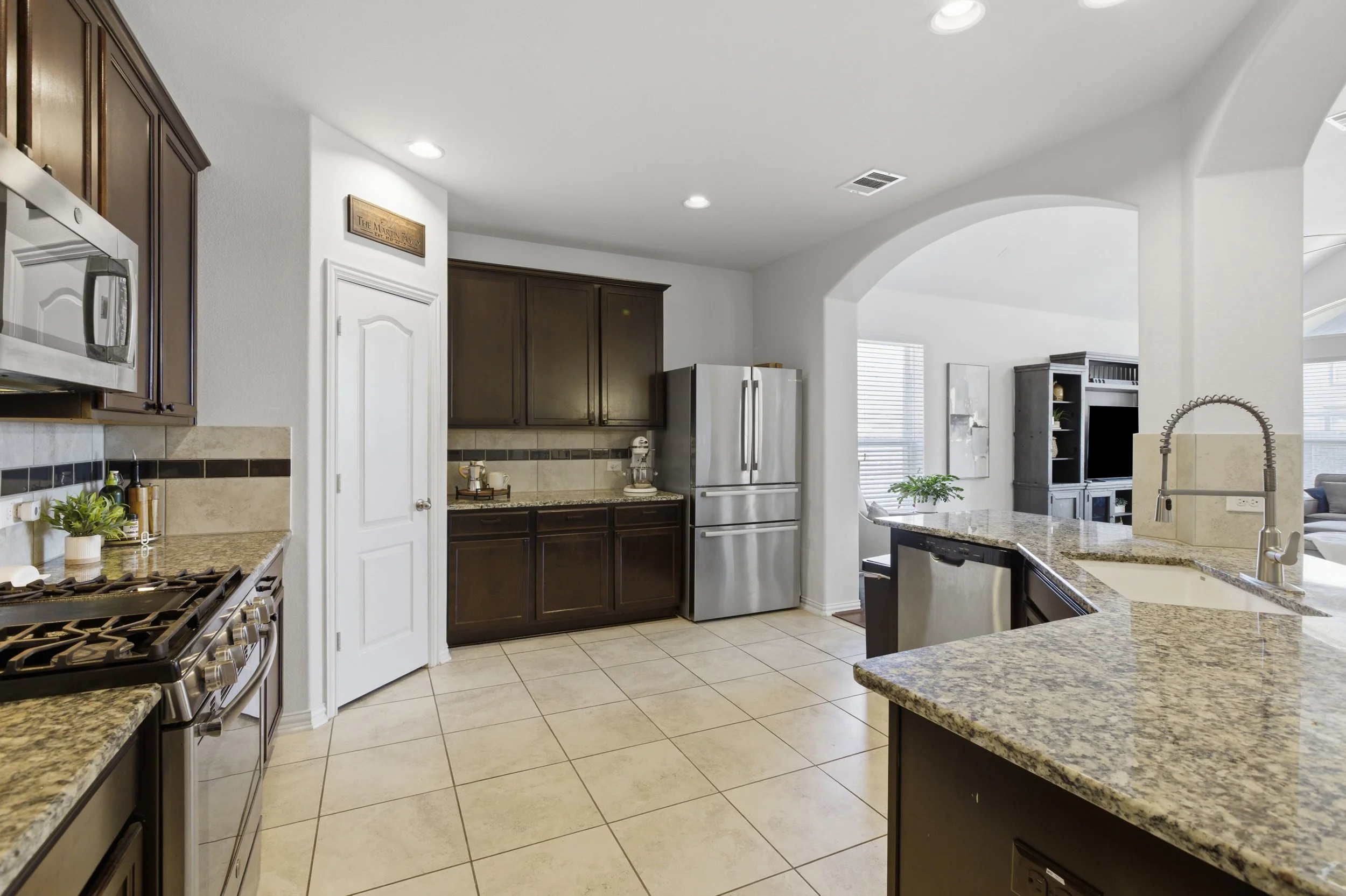 Modern kitchen at 5386 Parma St Round Rock TX featuring granite countertops, large island, and stainless steel appliances.