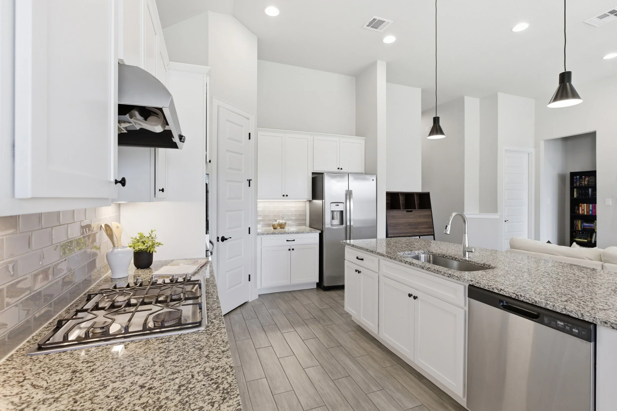 The kitchen features granite countertops, a large center island, built-in appliances, and a walk-in pantry | Georgetown, TX