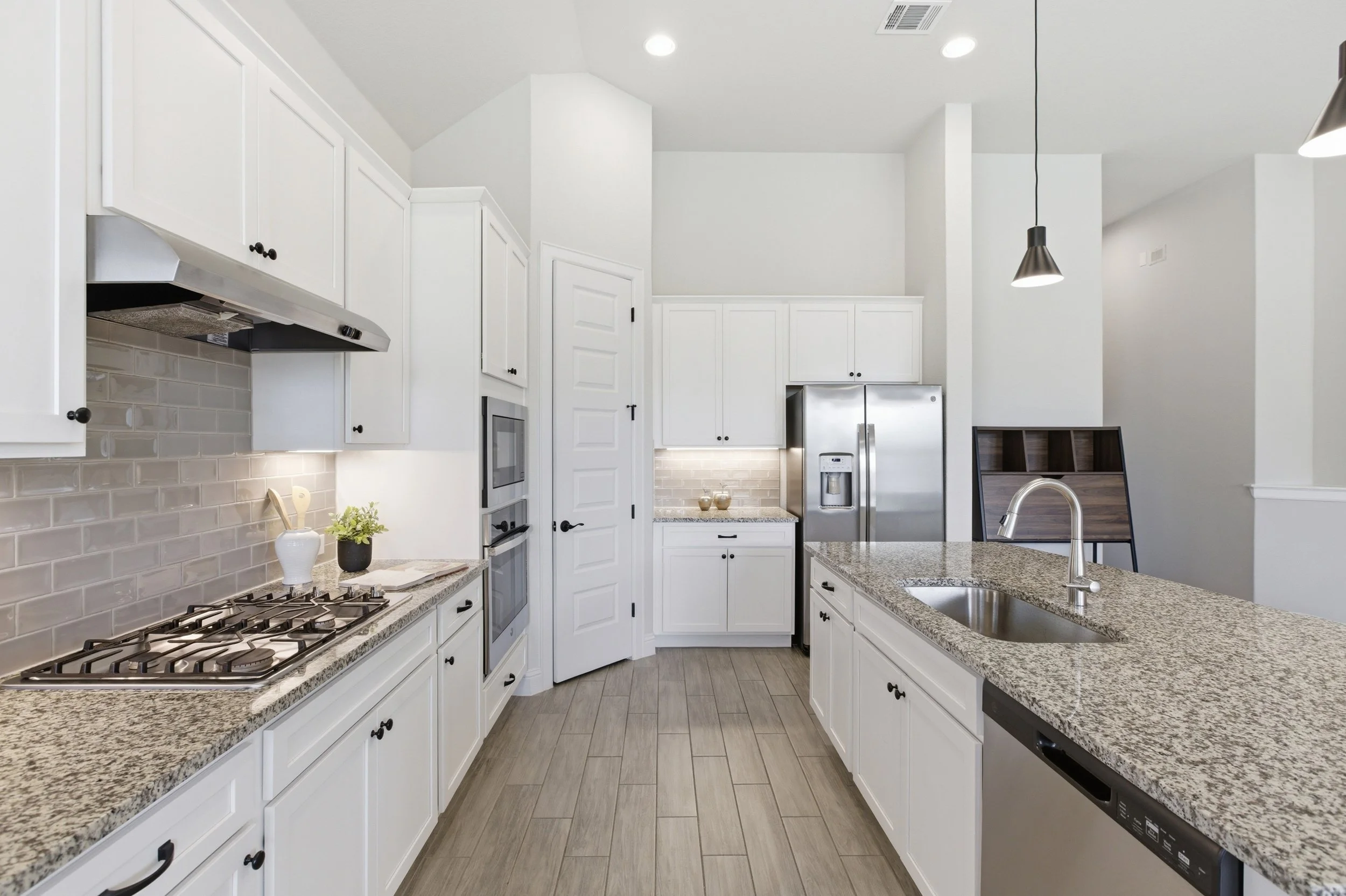 The kitchen features granite countertops, a large center island, built-in appliances, and a walk-in pantry | Georgetown, TX