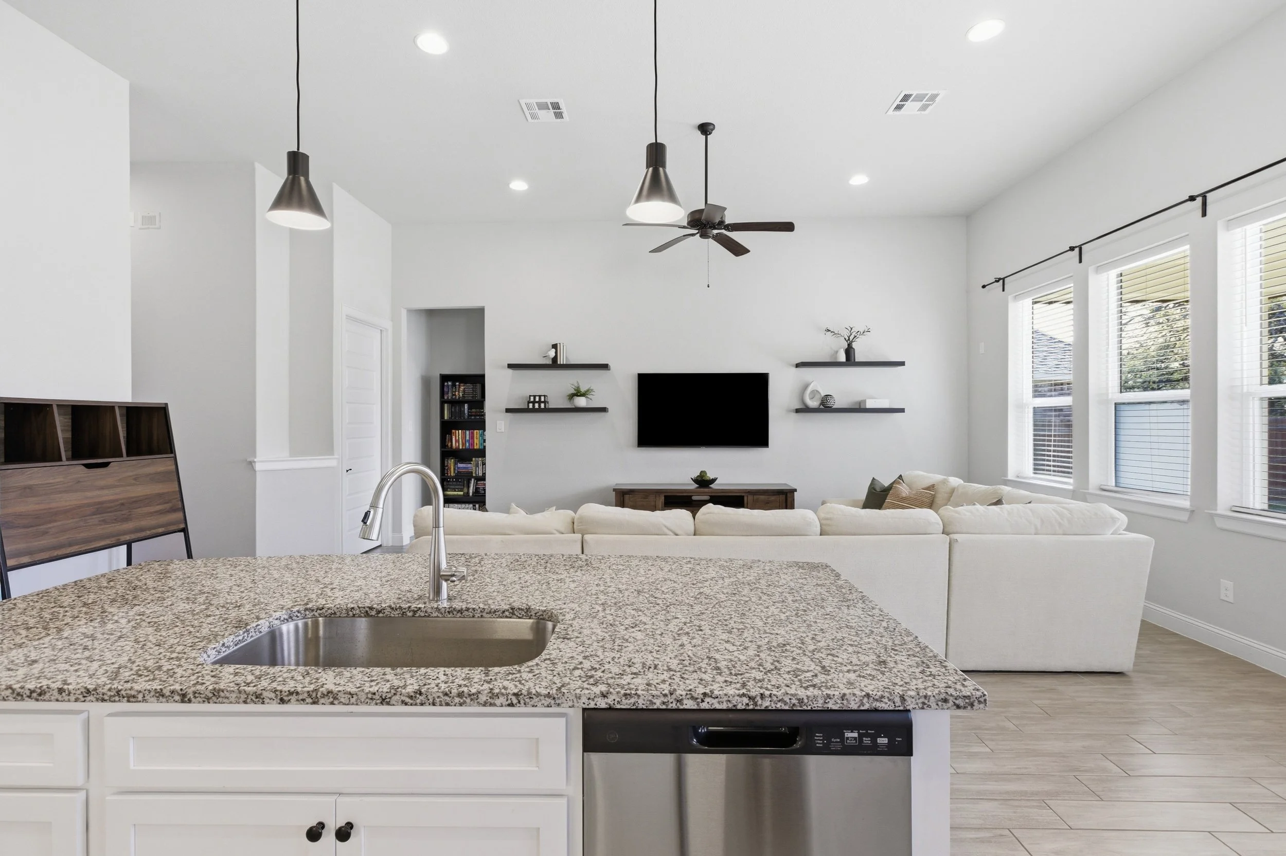 The kitchen features granite countertops, a large center island, built-in appliances, and a walk-in pantry | Georgetown, TX