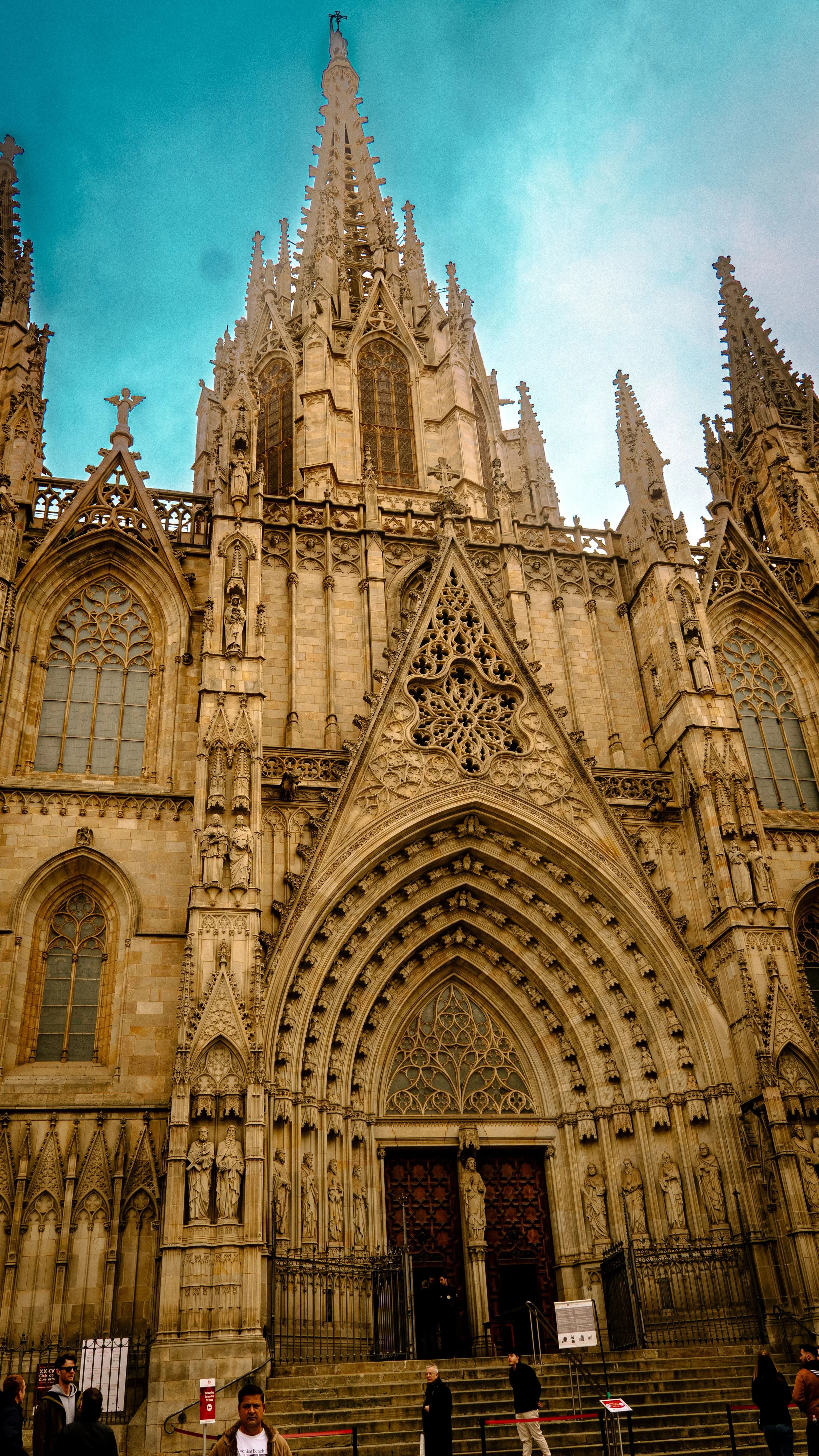 Front view of a Gothic cathedral with ornate stone carvings and large stained glass windows.