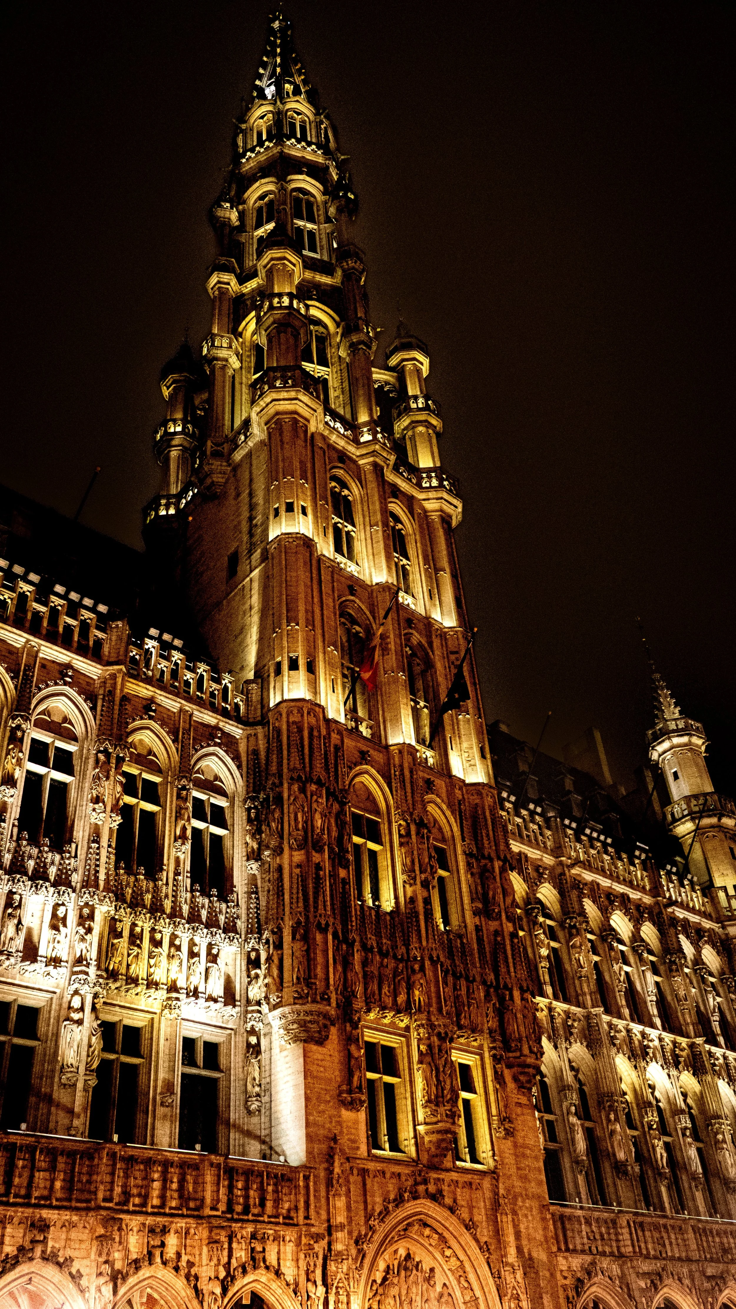 A tall, illuminated historic building at night with detailed architecture.