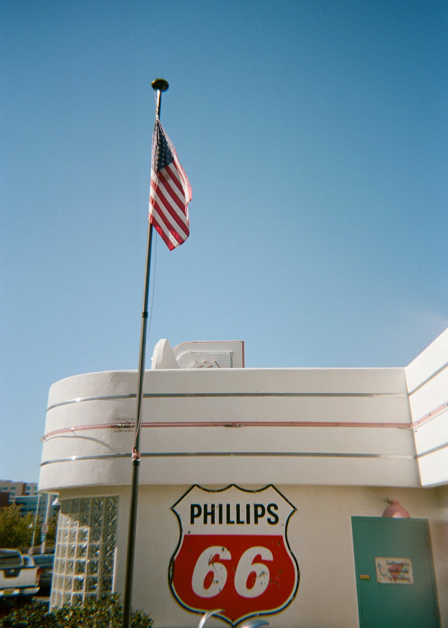 American flag flying near a vintage building with a Phillips 66 sign.